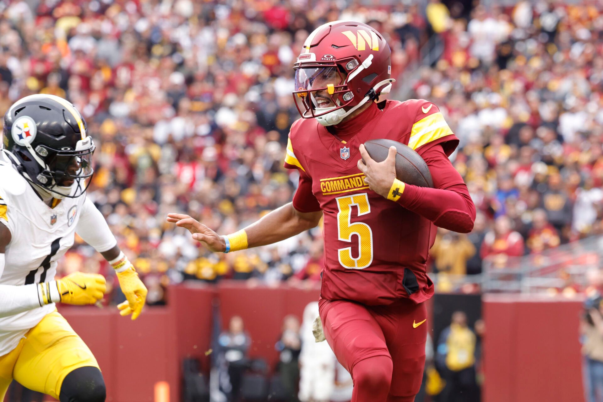 Nov 10, 2024; Landover, Maryland, USA; Washington Commanders quarterback Jayden Daniels (5) carries the ball as Pittsburgh Steelers linebacker Patrick Queen (6) defends during the first half at Northwest Stadium. Mandatory Credit: Amber Searls-Imagn Images