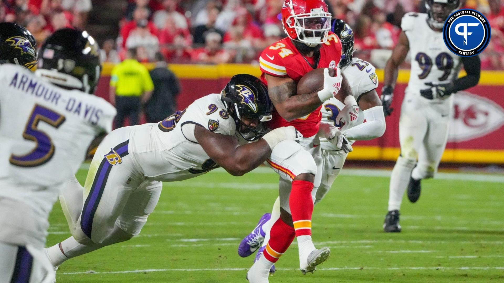 Kansas City Chiefs running back Samaje Perine (34) runs the ball as Baltimore Ravens defensive tackle Travis Jones (98) makes the tackle during the second half at GEHA Field at Arrowhead Stadium.