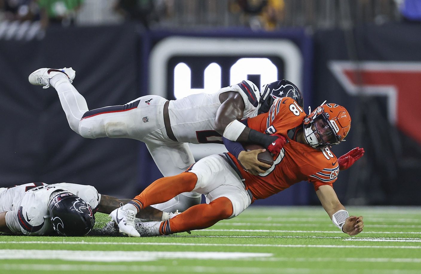 Houston Texans linebacker Azeez Al-Shaair (0) tackles Chicago Bears quarterback Caleb Williams (18) during the fourth quarter at NRG Stadium. Mandatory Credit: Troy Taormina-Imagn Images