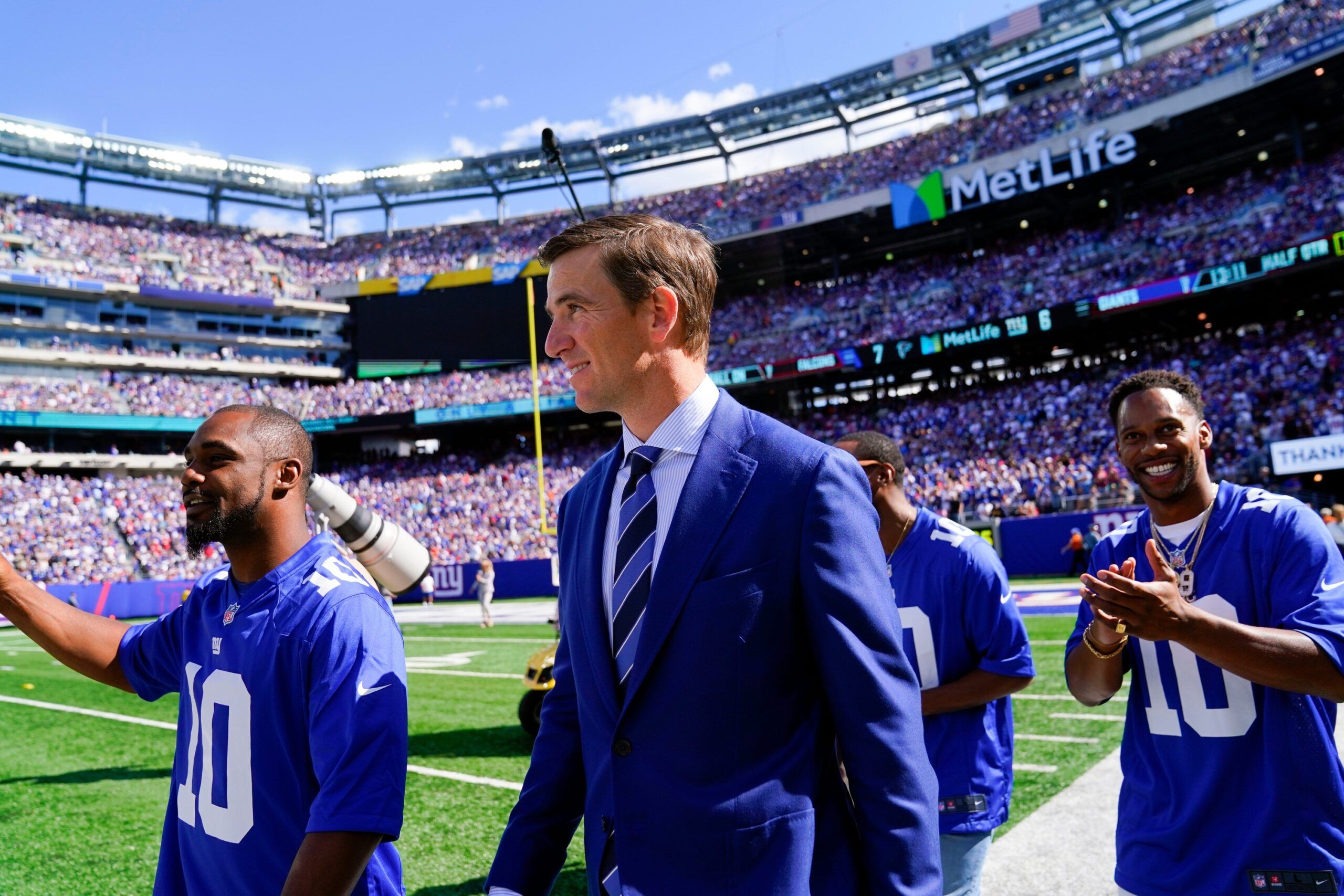 Former New York Giants quarterback Eli Manning, center, walks onto the field with teammates Ahmad Bradshaw, left, and Victor Cruz, right, for his Ring of Honor ceremony at MetLife Stadium on Sunday, Sept. 26, 2021, in East Rutherford. Nyg Vs Atl