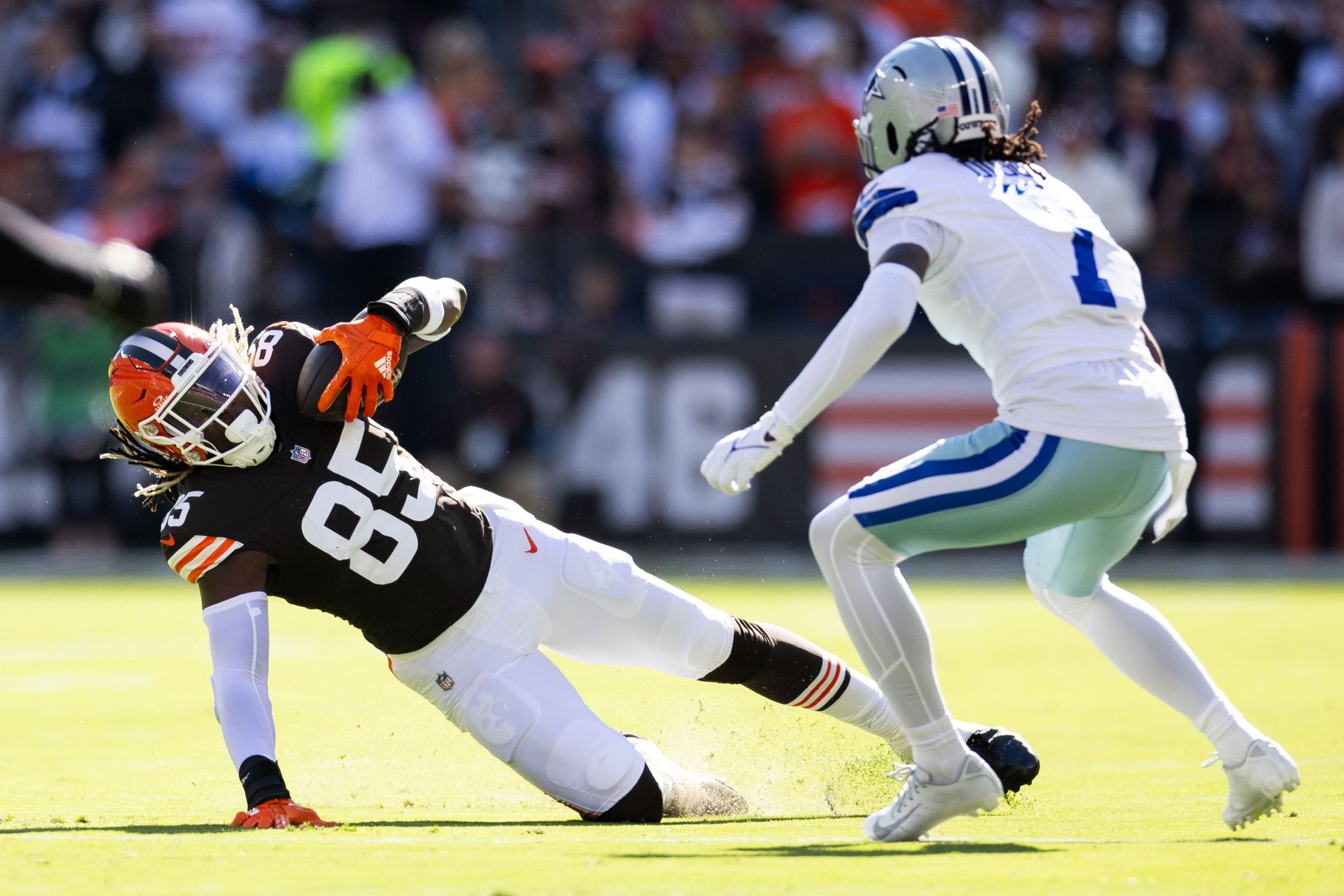 Cleveland Browns tight end David Njoku (85) falls while running the ball under coverage by Dallas Cowboys cornerback Trevon Diggs (7) during the first quarter at Huntington Bank Field. Mandatory Credit: Scott Galvin-Imagn Images