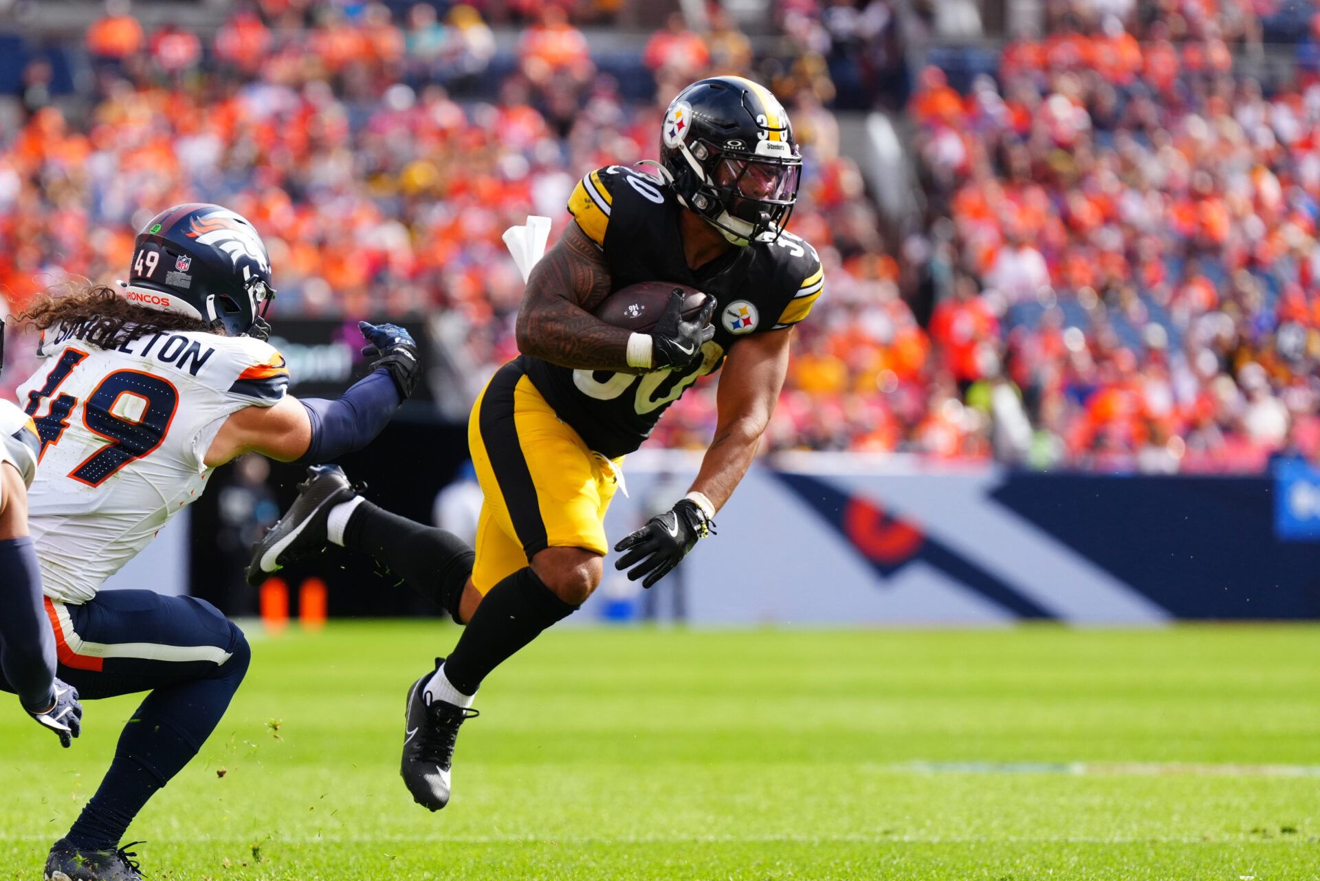 Sep 15, 2024; Denver, Colorado, USA; Pittsburgh Steelers running back Jaylen Warren (30) catches the ball past Denver Broncos linebacker Alex Singleton (49) in the second quarter at Empower Field at Mile High. Mandatory Credit: Ron Chenoy-Imagn Images