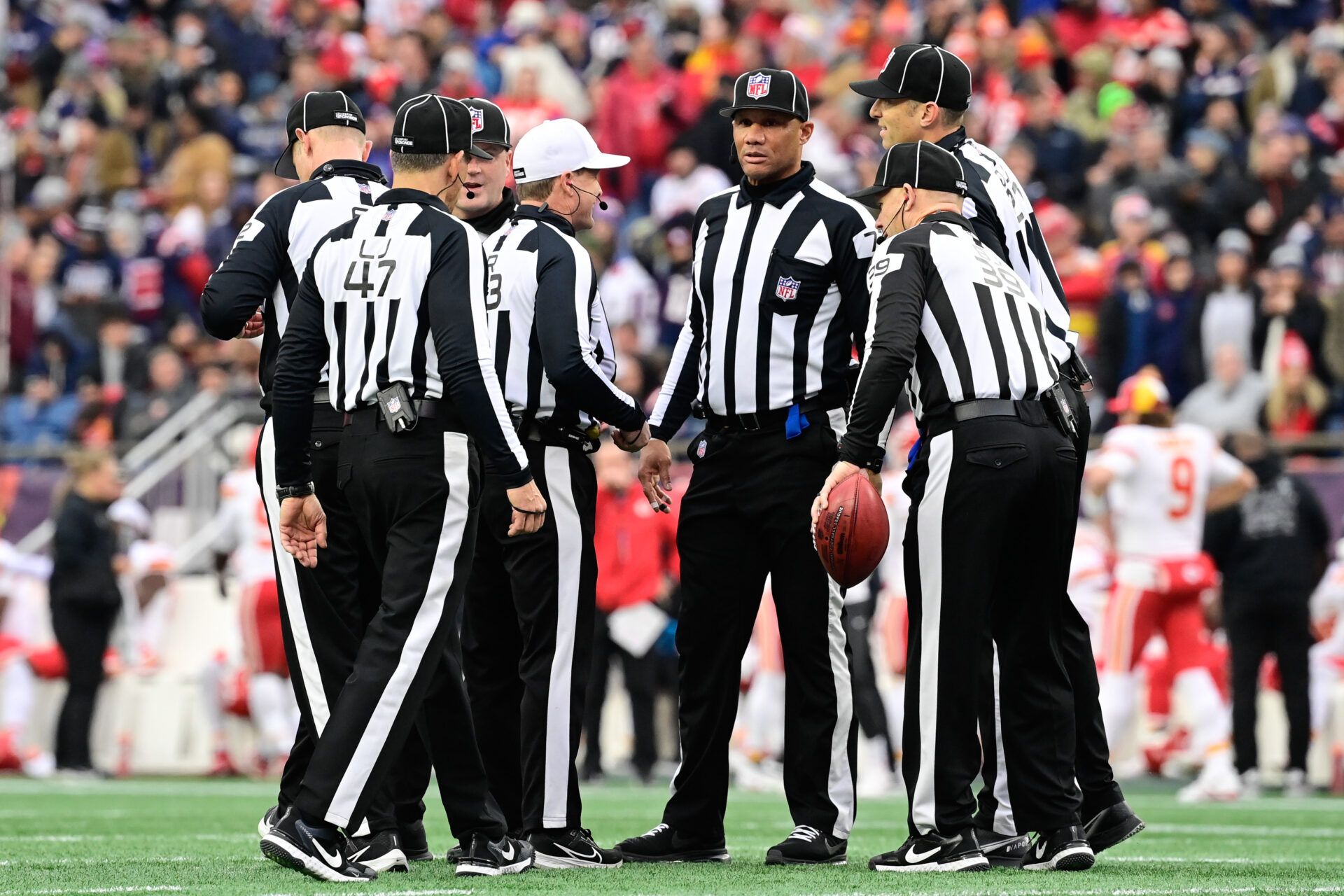 Dec 17, 2023; Foxborough, Massachusetts, USA; NFL referee Shawn Hochuli (83) huddles with his crew during a timeout on the field during the first half of a game between the New England Patriots and the Kansas City Chiefs at Gillette Stadium. Mandatory Credit: Eric Canha-USA TODAY Sports