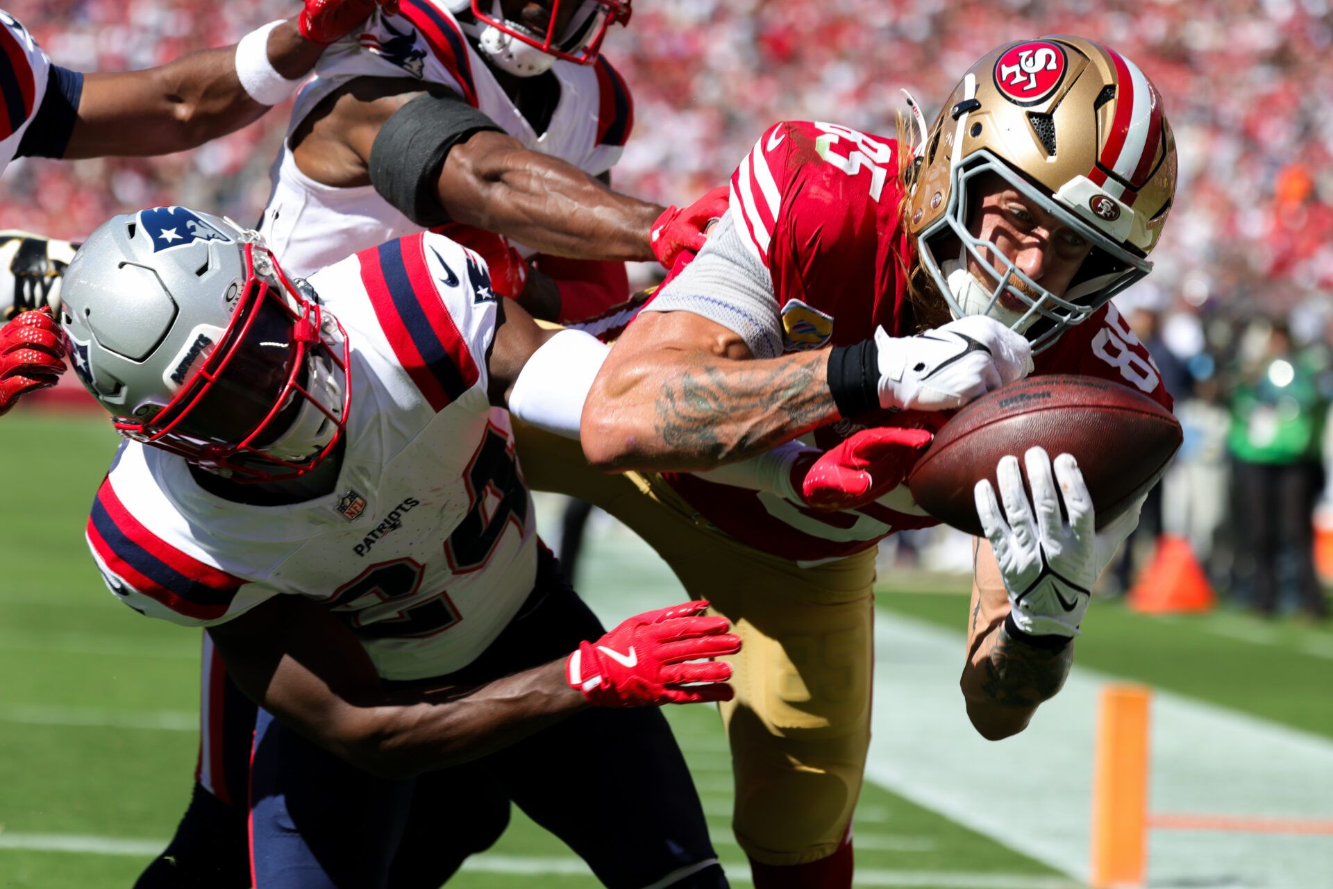 Sep 29, 2024; Santa Clara, California, USA; San Francisco 49ers tight end George Kittle (85) catches a touchdown against New England Patriots safety Dell Pettus (24) during the second quarter at Levi's Stadium. Mandatory Credit: Sergio Estrada-Imagn Images