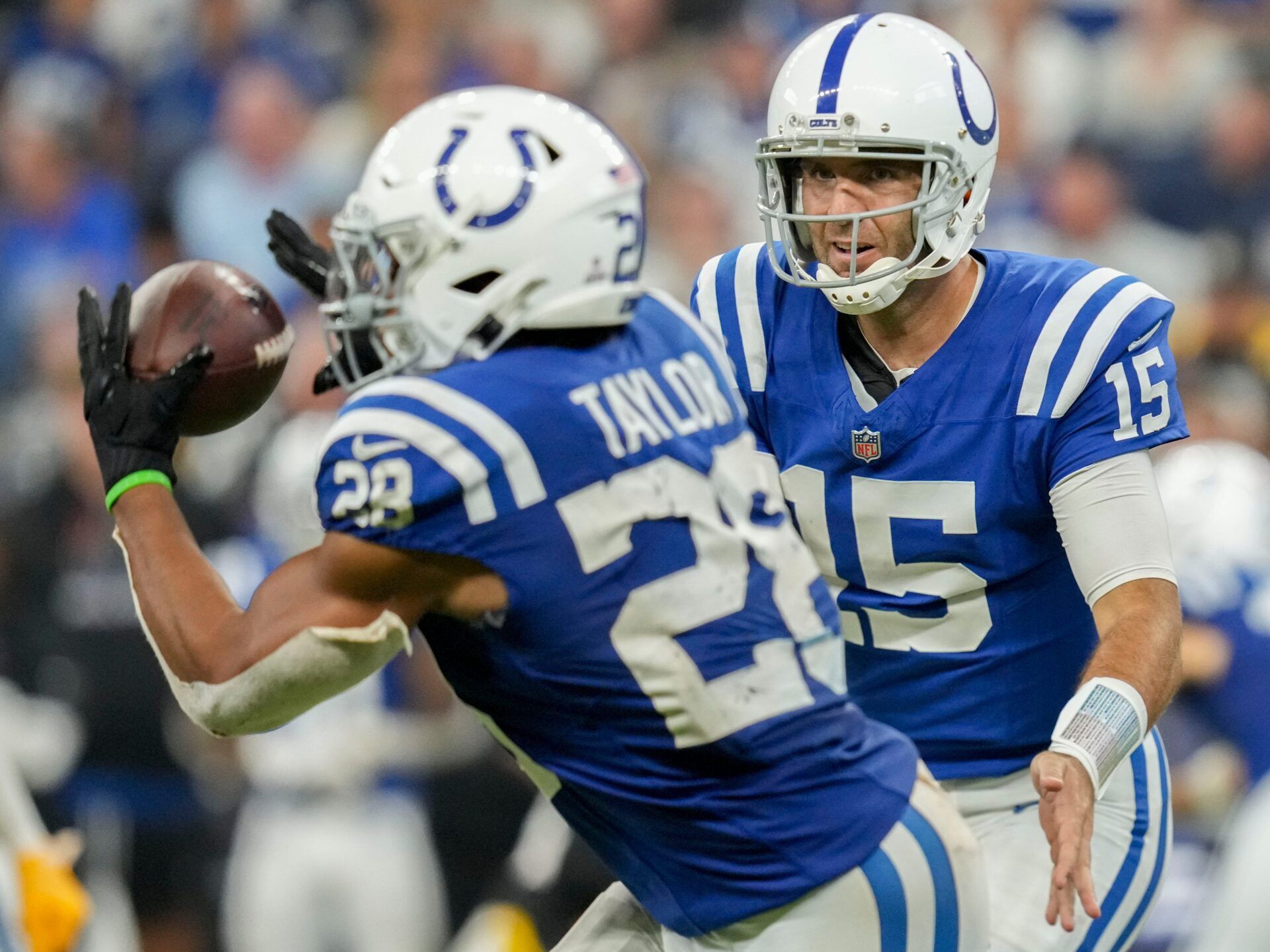 Indianapolis Colts quarterback Joe Flacco (15) tosses the ball to Indianapolis Colts running back Jonathan Taylor (28) on Sunday, Sept. 29, 2024, during a game against the Pittsburgh Steelers at Lucas Oil Stadium in Indianapolis.