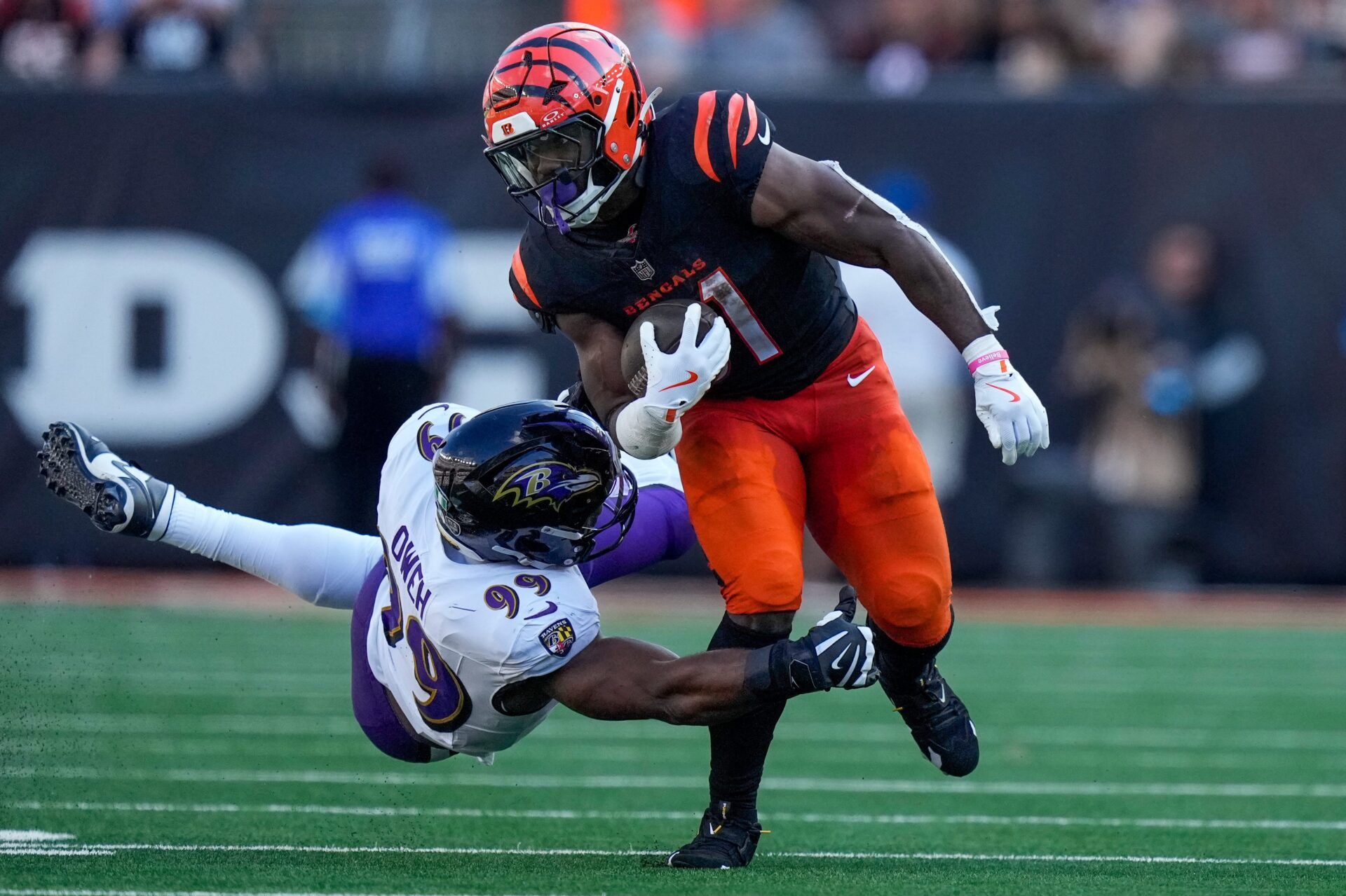 Cincinnati Bengals halfback Zack Moss (31) runs from a tackle by Baltimore Ravens outside linebacker Odafe Oweh (99) in the fourth quarter of the NFL Week 5 game between the Cincinnati Bengals and Baltimore Ravens at Paycor Stadium in downtown Cincinnati on Sunday, Oct. 6, 2024. The Bengals fell to 1-4 on the season with a 41-38 loss to the Ravens.