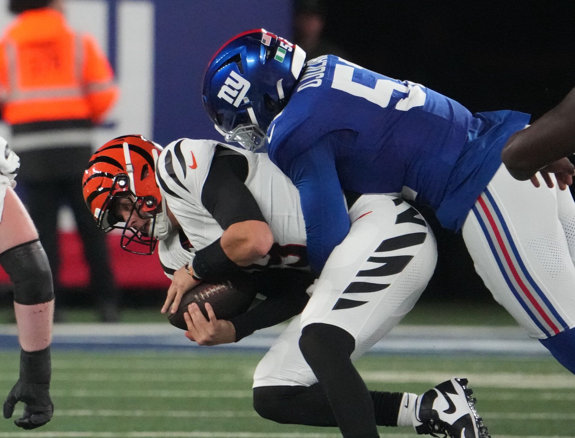 Oct 13, 2024; East Rutherford, New Jersey, USA; New York Giants linebacker Azeez Ojulari (51) tackles Cincinnati Bengals quarterback Joe Burrow (9) during the first half at MetLife Stadium. Mandatory Credit: Robert Deutsch-Imagn Images
