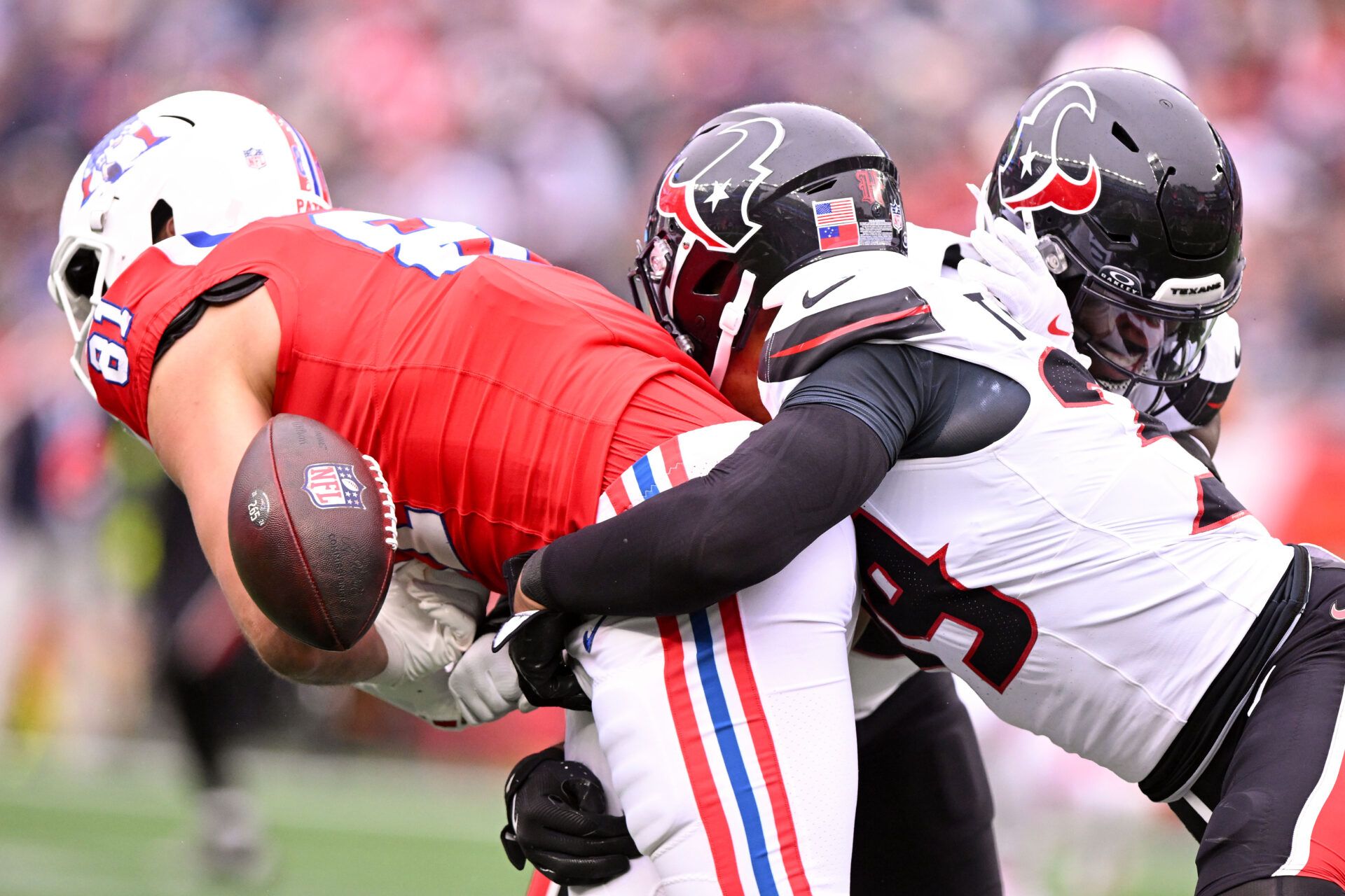 New England Patriots tight end Austin Hooper (81) fumbles the ball after a tackle by Houston Texans linebacker Azeez Al-Shaair (0) and linebacker Henry To'oTo'o (39) during the second half at Gillette Stadium.