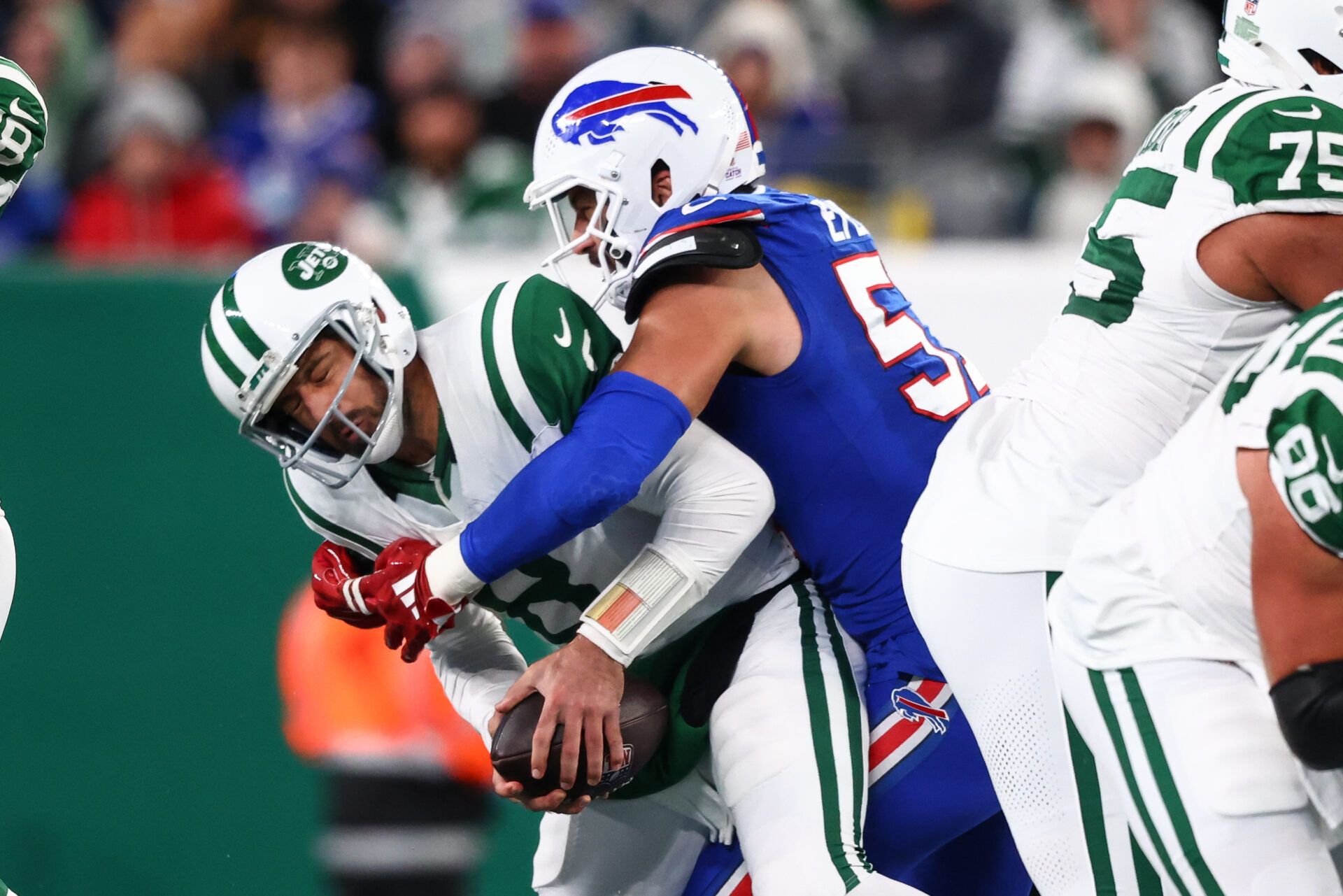 Oct 14, 2024; East Rutherford, New Jersey, USA; New York Jets quarterback Aaron Rodgers (8) is sacked by Buffalo Bills defensive end AJ Epenesa (57) during the first half at MetLife Stadium. Mandatory Credit: Ed Mulholland-Imagn Images