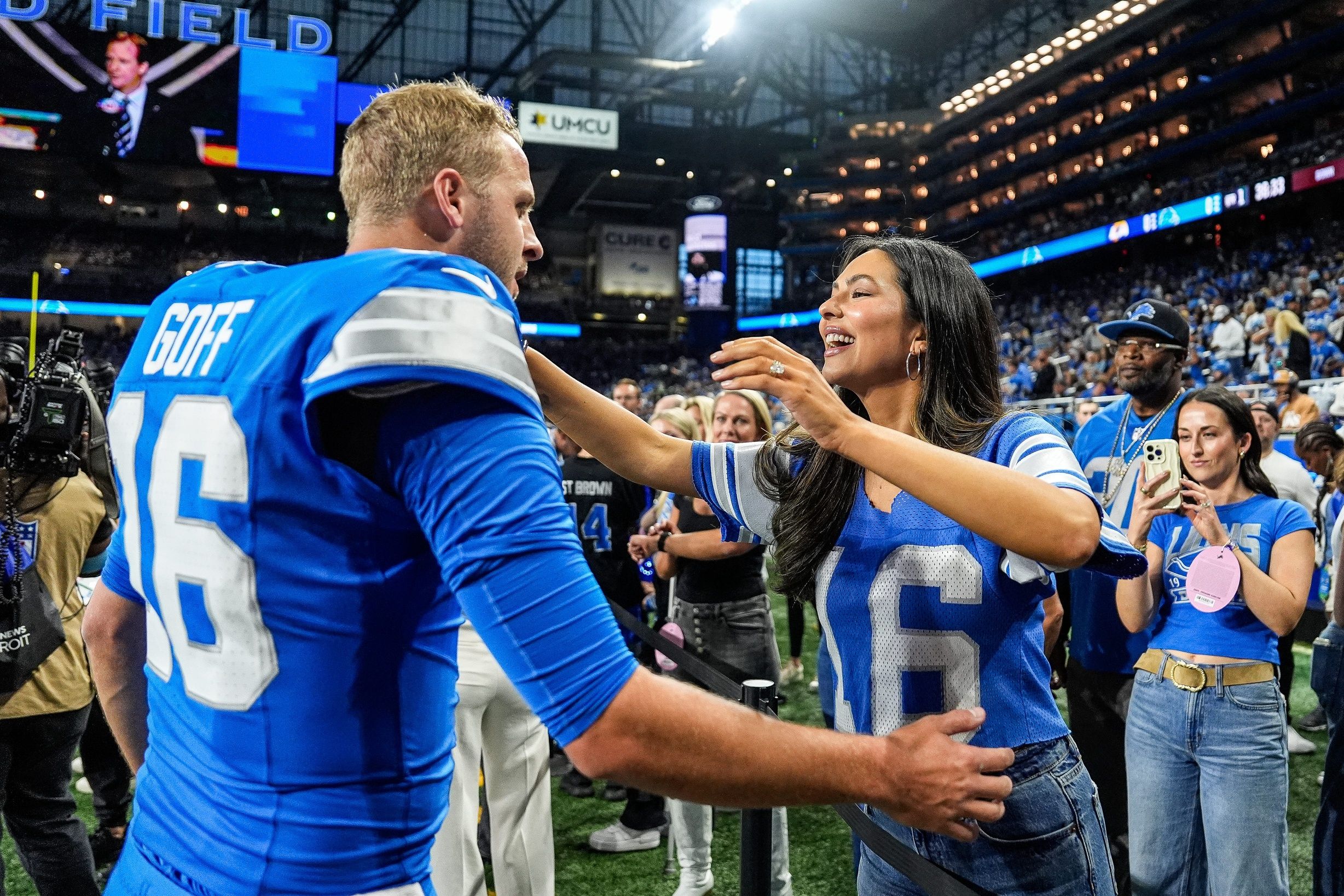 Detroit Lions quarterback Jared Goff hugs his wife Christen Harper during warmups before the Los Angeles Rams game at Ford Field in Detroit on Sunday, Sept. 8, 2024.