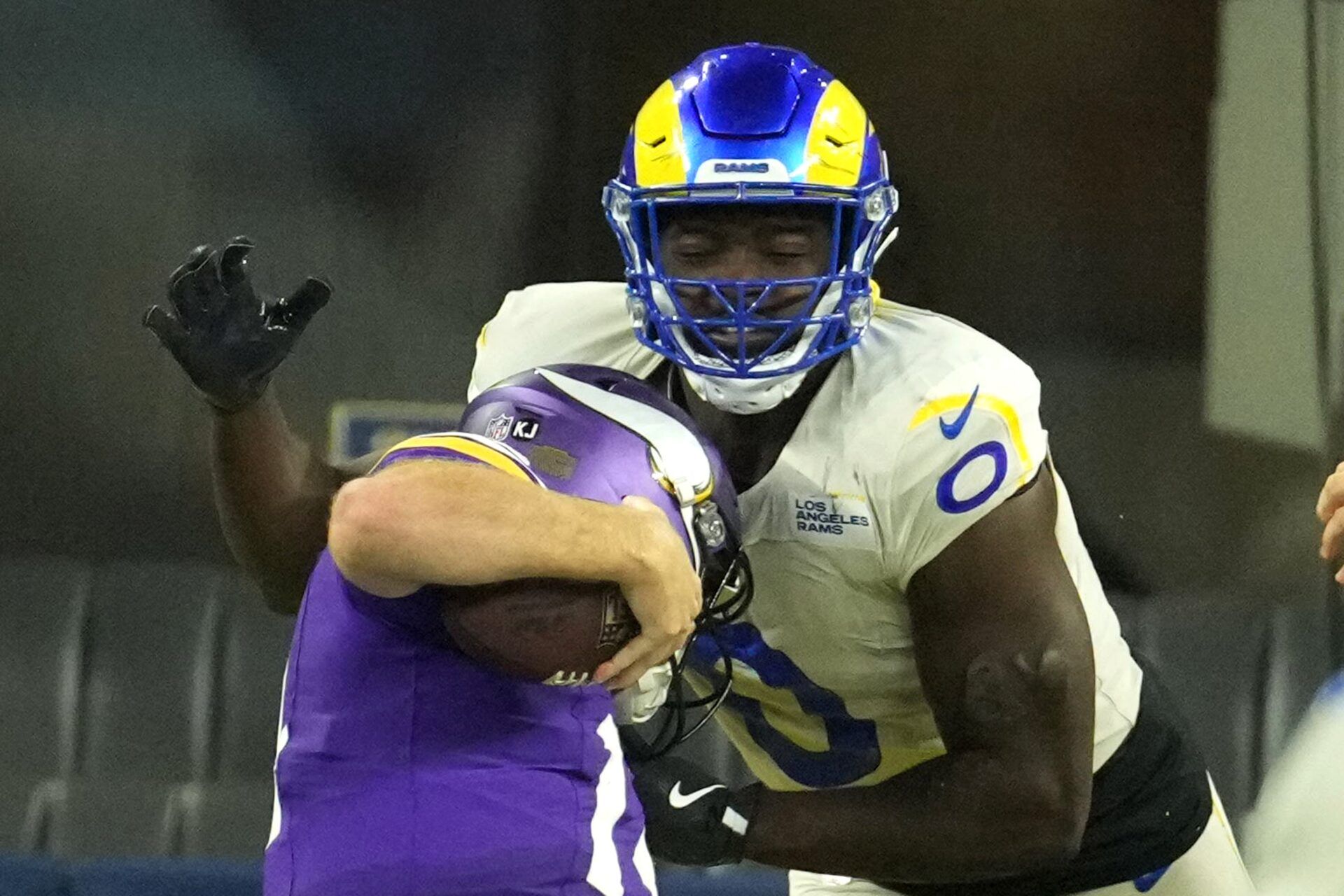 Los Angeles Rams linebacker Byron Young (0) tackles Minnesota Vikings quarterback Sam Darnold (14) for a safety in the second half at SoFi Stadium.