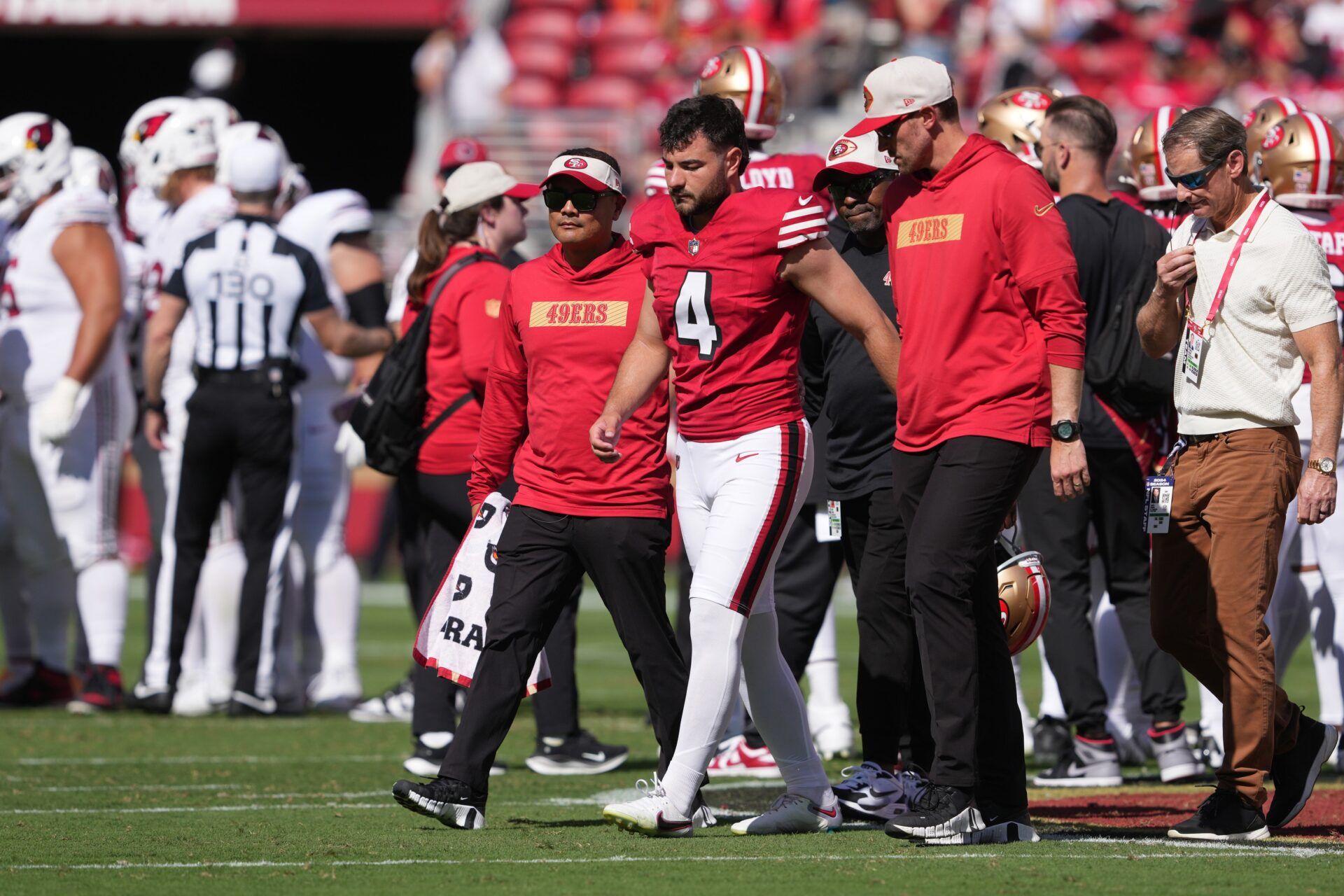 San Francisco 49ers place kicker Jake Moody (4) walks off of the field with medical personnel after suffering an injury against the Arizona Cardinals during the second quarter at Levi's Stadium.