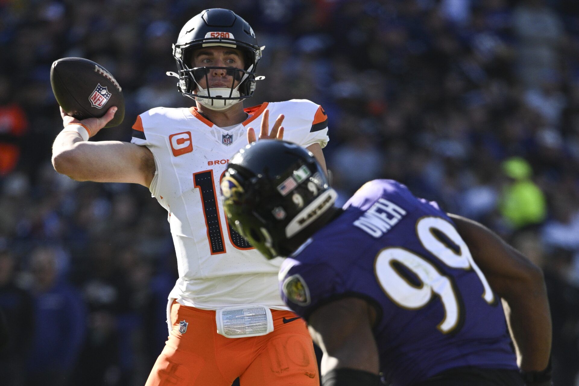 Nov 3, 2024; Baltimore, Maryland, USA; Denver Broncos quarterback Bo Nix (10) throws as Baltimore Ravens linebacker Odafe Oweh (99) defends xduring the first half at M&T Bank Stadium. Mandatory Credit: Tommy Gilligan-Imagn Images