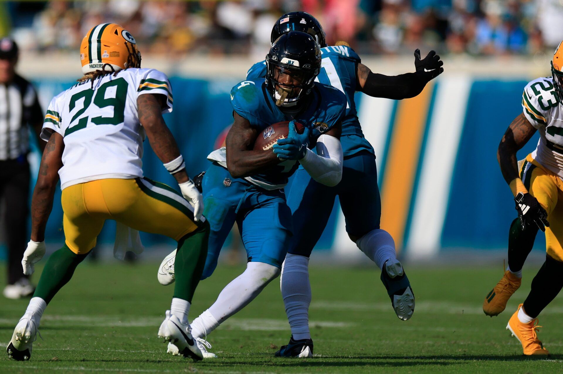 Jacksonville Jaguars running back Tank Bigsby (4) rushes for yards against Green Bay Packers safety Xavier McKinney (29) during the fourth quarter of an NFL football matchup Sunday, Oct. 27, 2024 at EverBank Stadium in Jacksonville, Fla. The Packers edged the Jaguars 30-27 on a last-second field goal. [Corey Perrine/Florida Times-Union]