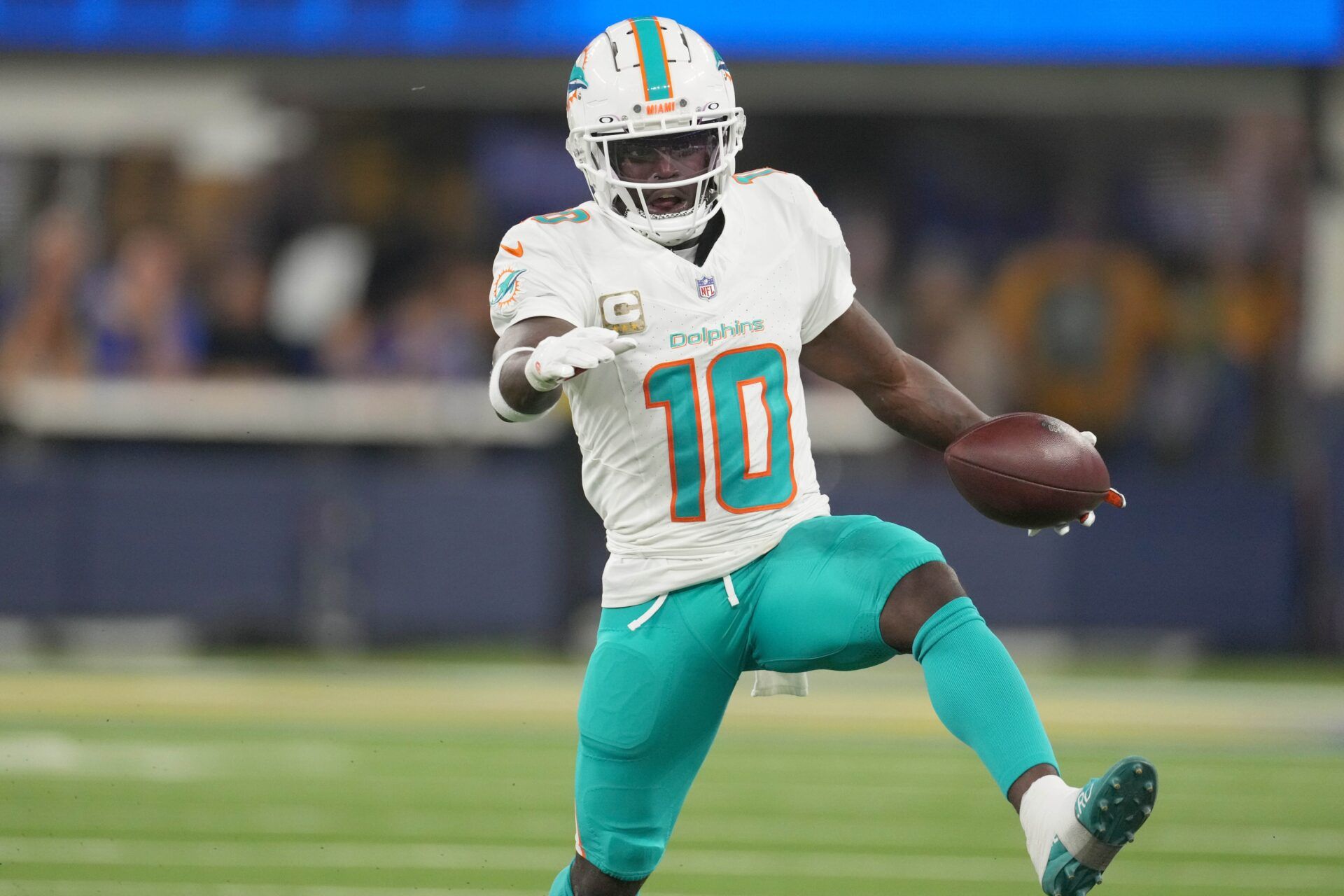 Nov 11, 2024; Inglewood, California, USA; Miami Dolphins wide receiver Tyreek Hill (10) carries the ball against the Los Angeles Rams in the first half at SoFi Stadium. Mandatory Credit: Kirby Lee-Imagn Images