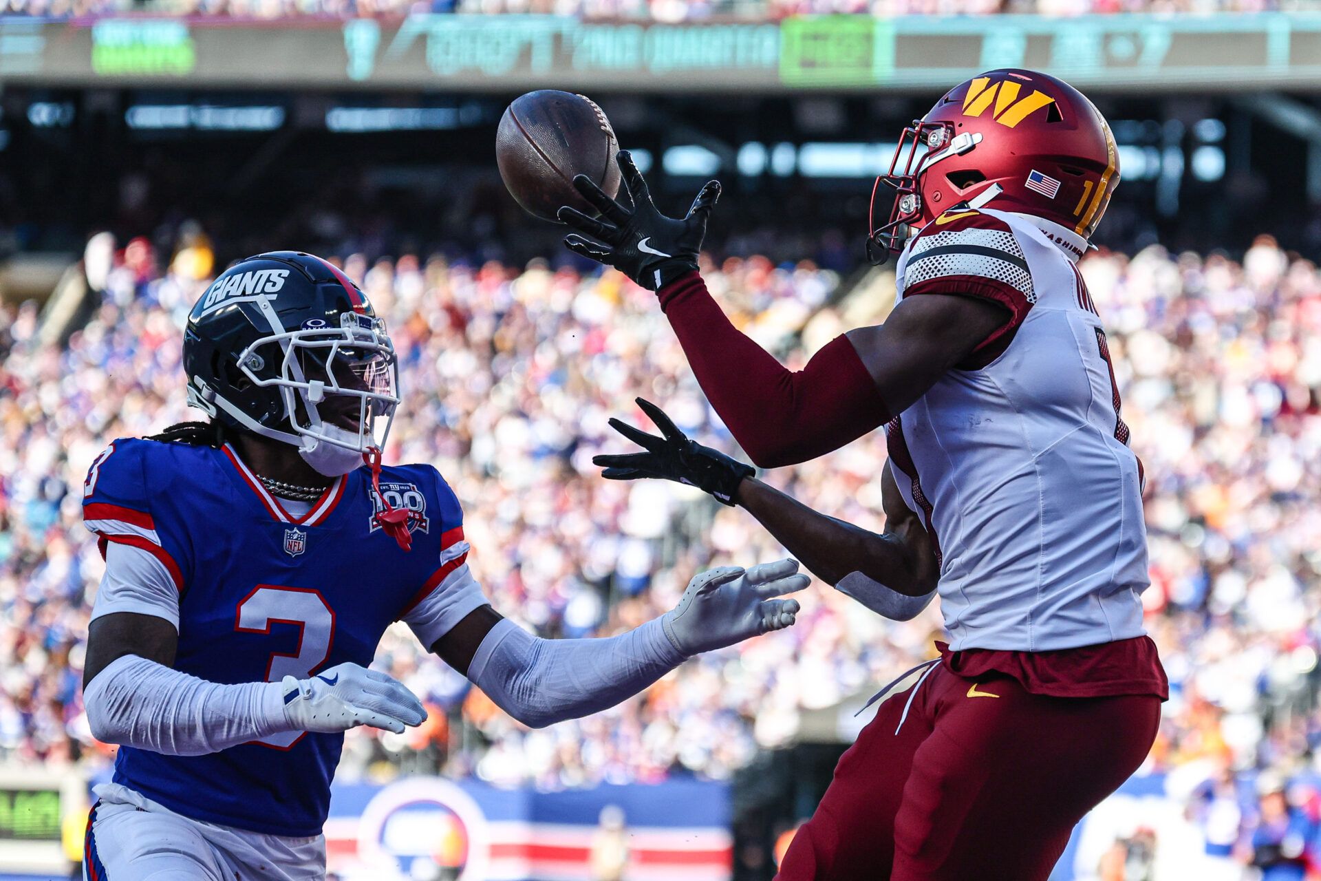 Nov 3, 2024; East Rutherford, New Jersey, USA; Washington Commanders wide receiver Terry McLaurin (17) catches a touchdown pass as New York Giants cornerback Deonte Banks (3) defends during the first half at MetLife Stadium. Mandatory Credit: Vincent Carchietta-Imagn Images