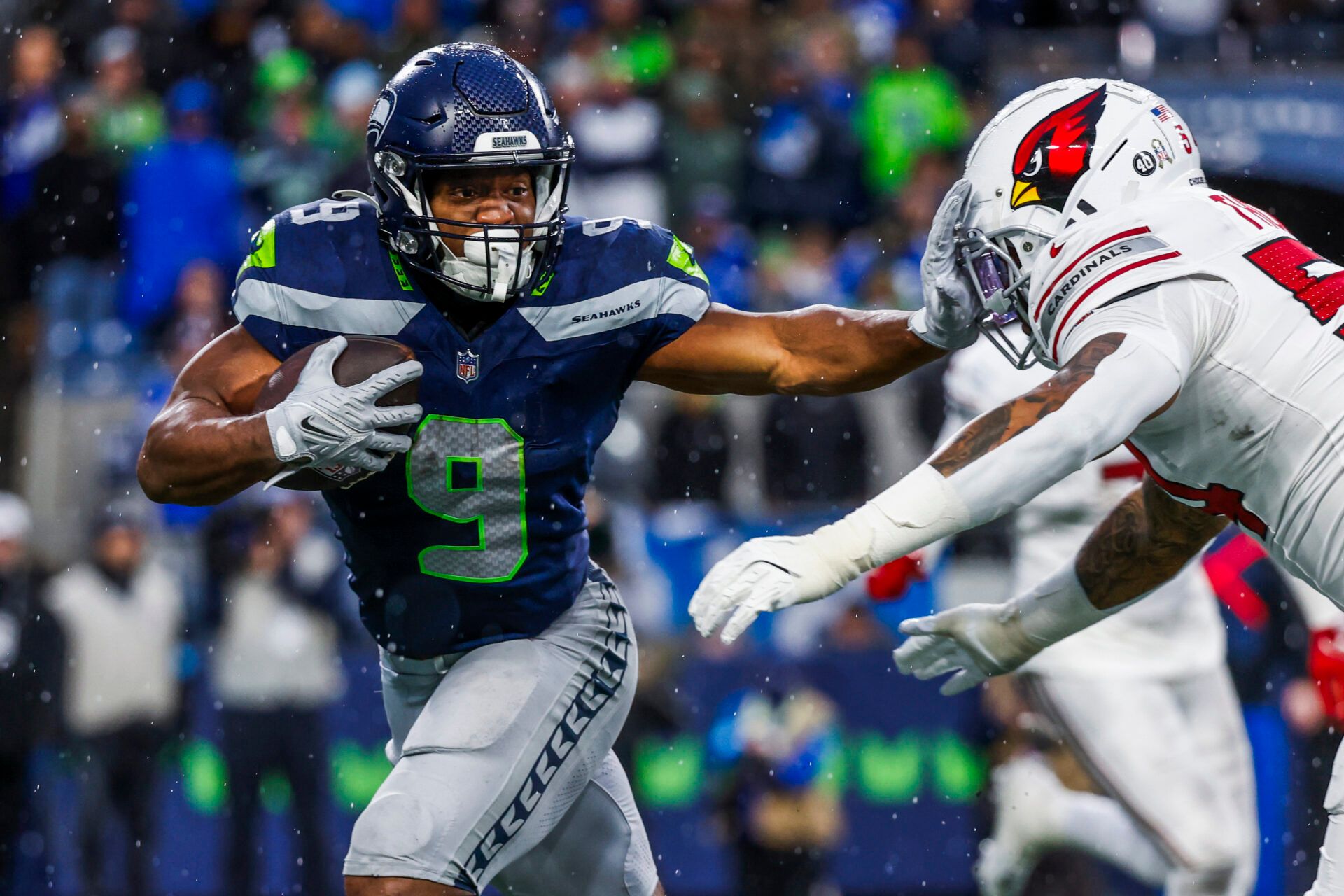 Nov 24, 2024; Seattle, Washington, USA; Seattle Seahawks running back Kenneth Walker III (9) stiff-arms away from a tackle attempt by Arizona Cardinals linebacker Xavier Thomas (54) after catching a pass during the fourth quarter at Lumen Field. Mandatory Credit: Joe Nicholson-Imagn Images