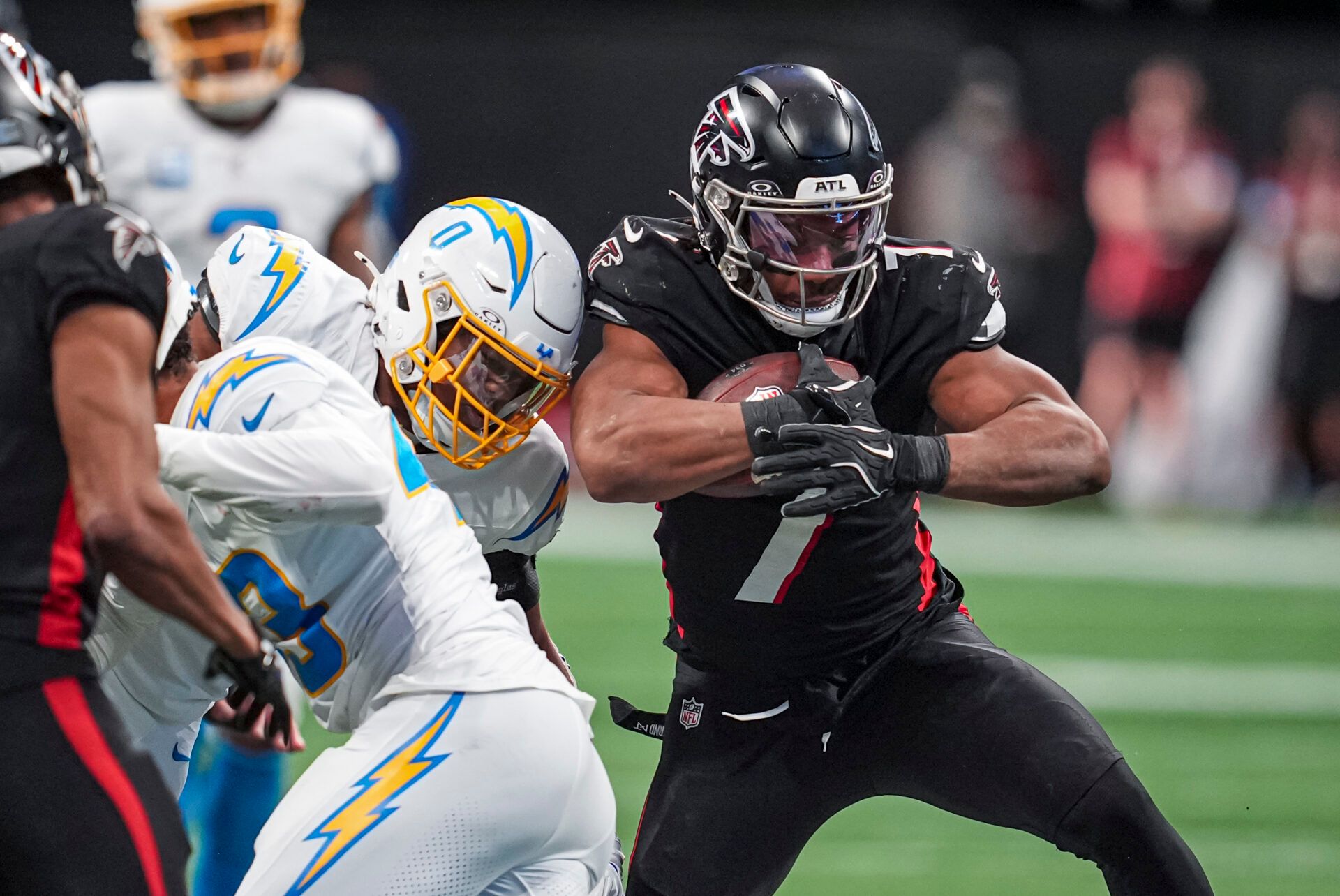 Dec 1, 2024; Atlanta, Georgia, USA; Atlanta Falcons running back Bijan Robinson (7) runs against Los Angeles Chargers linebacker Daiyan Henley (0) during the second half at Mercedes-Benz Stadium. Mandatory Credit: Dale Zanine-Imagn Images