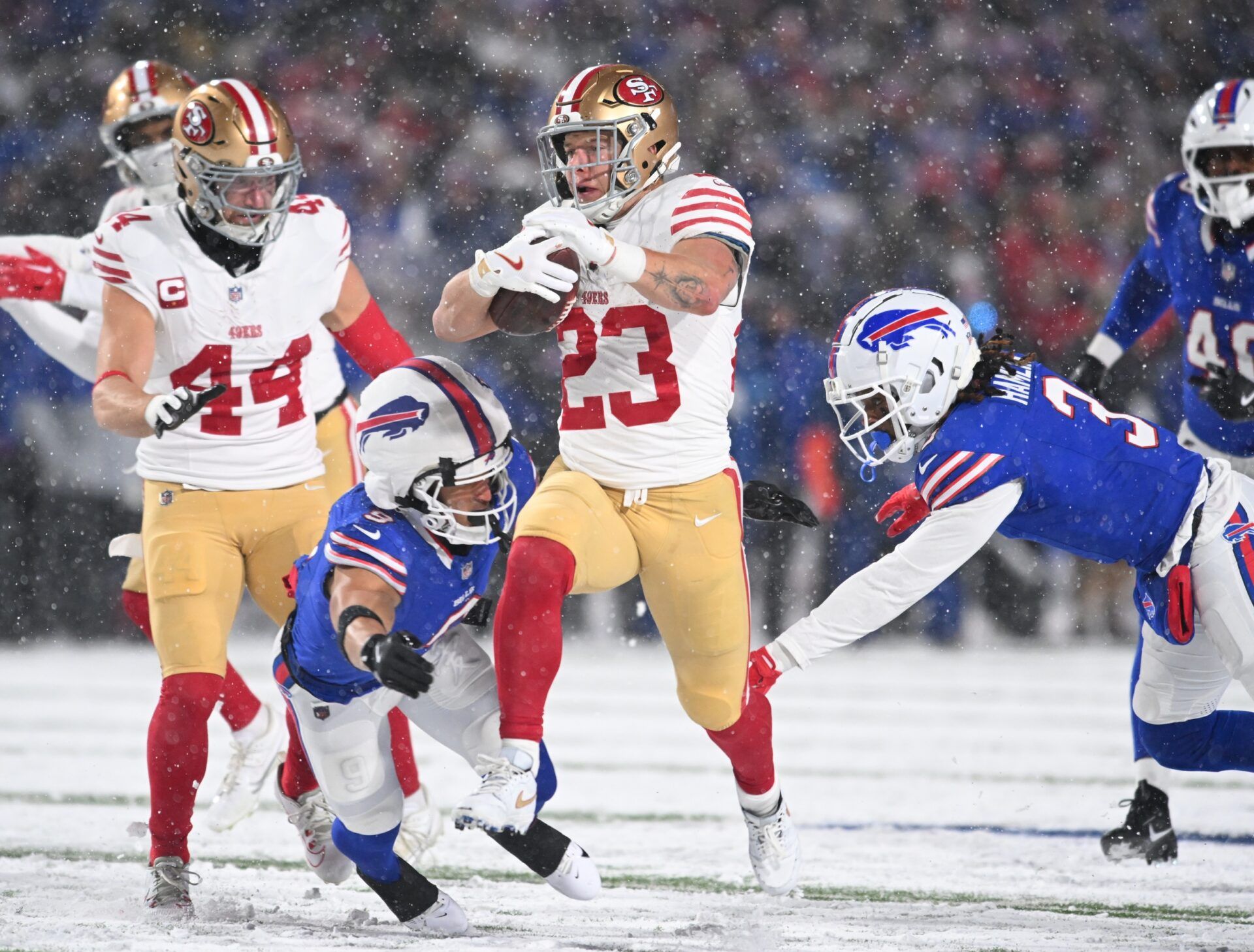 San Francisco 49ers running back Christian McCaffrey (23) is tackled by Buffalo Bills safety Taylor Rapp (9) and safety Damar Hamlin (3) in the second quarter at Highmark Stadium.