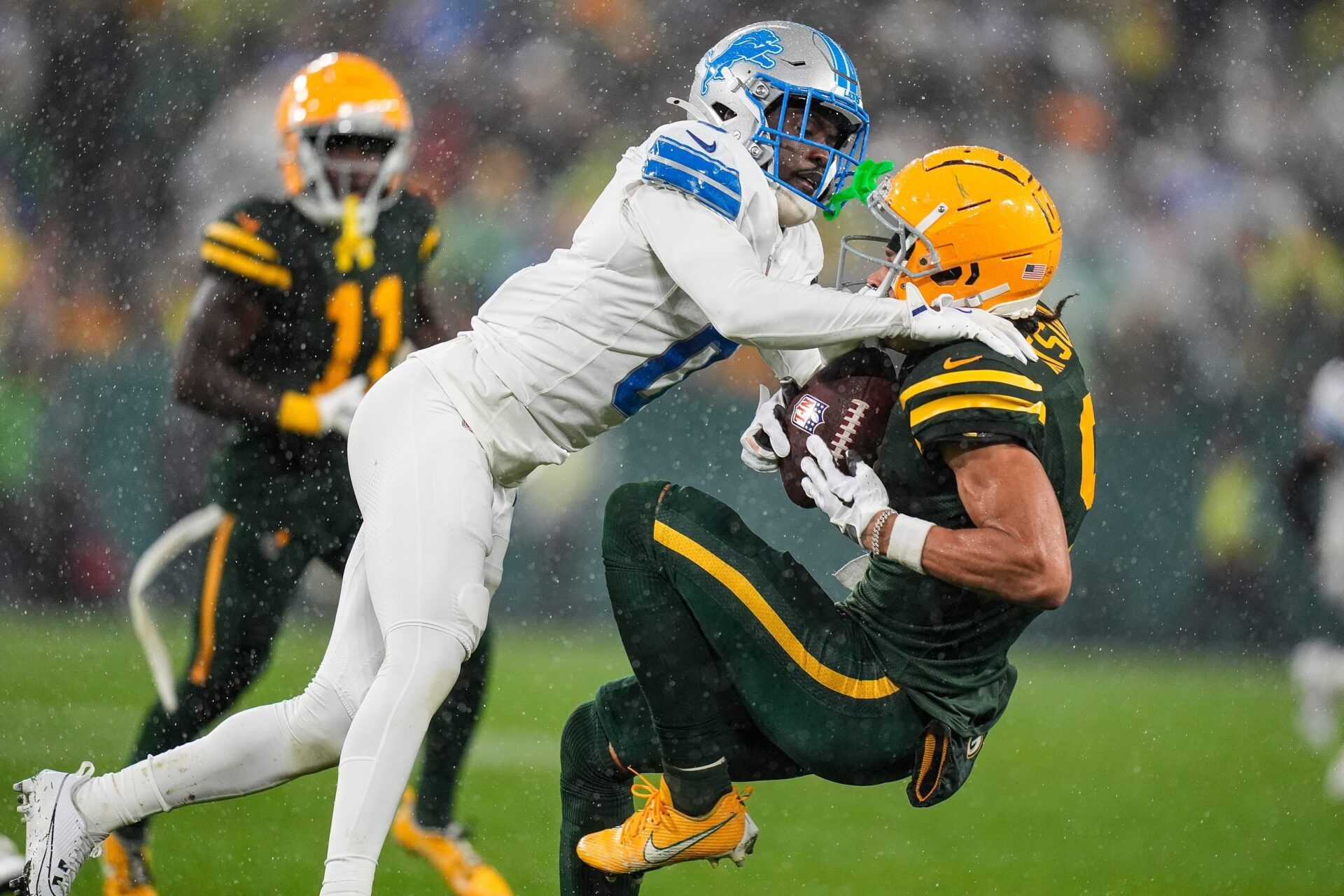 Detroit Lions cornerback Terrion Arnold (0) tackles Green Bay Packers wide receiver Christian Watson (9) during the second half at Lambeau Field in Green Bay, Wis. on Sunday, Nov. 3, 2024.