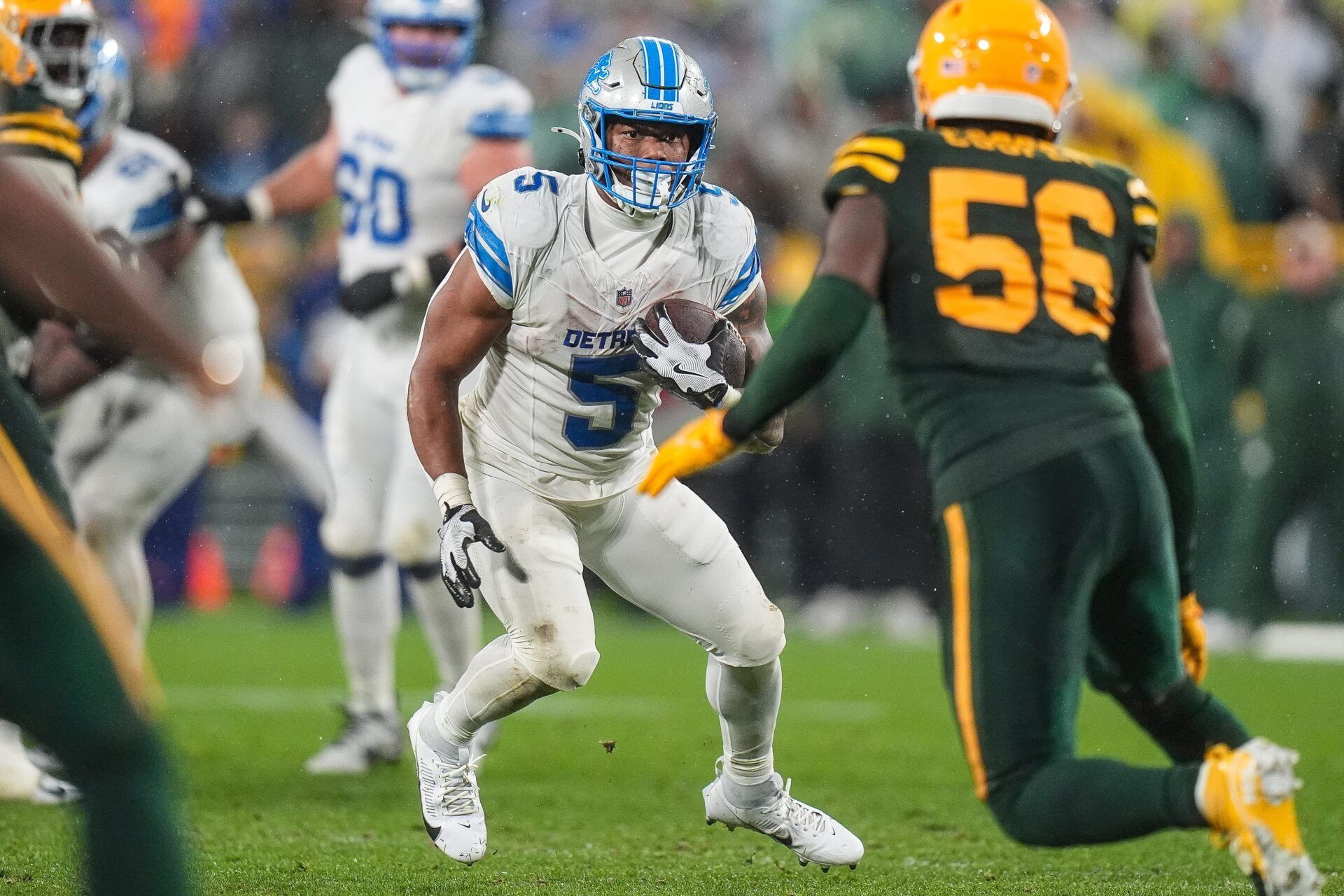 Detroit Lions running back David Montgomery (5) runs against Green Bay Packers linebacker Edgerrin Cooper (56) during the second half at Lambeau Field in Green Bay, Wis. on Sunday, Nov. 3, 2024.