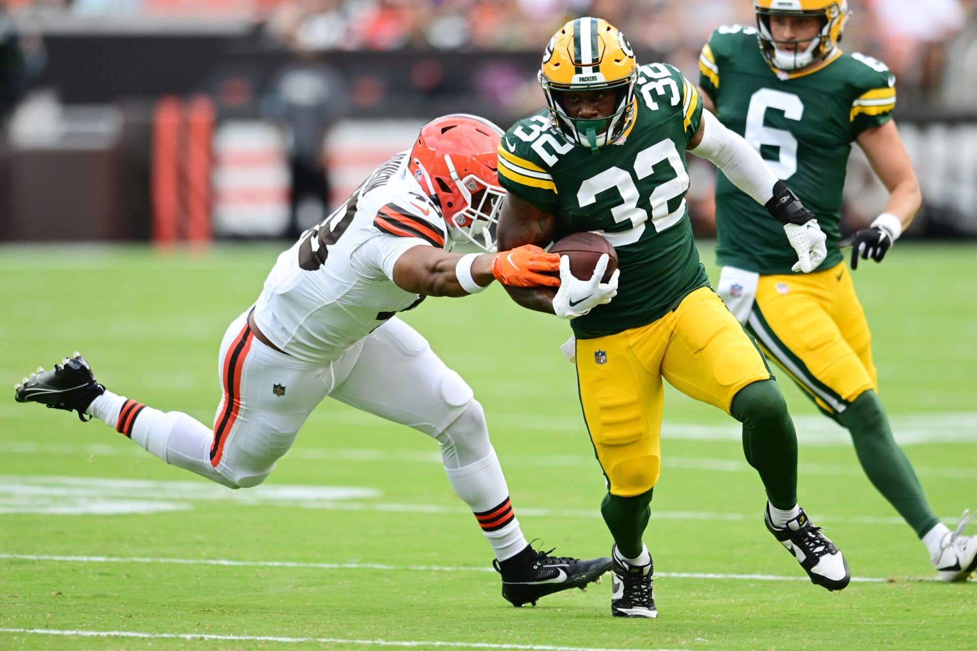 Green Bay Packers running back MarShawn Lloyd (32) runs with the ball as Cleveland Browns linebacker Caleb Johnson (48) defends during the second half at Cleveland Browns Stadium.