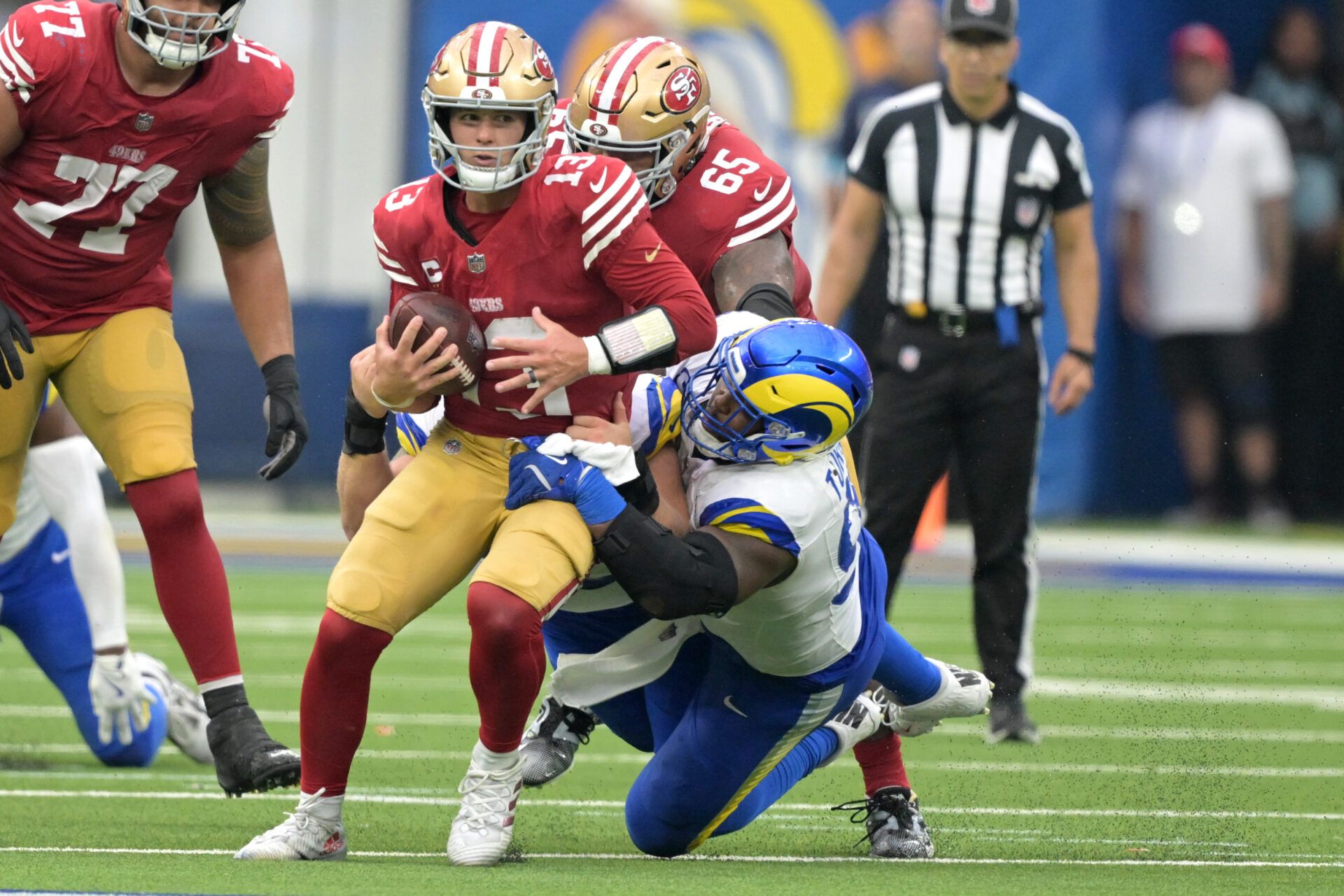 Sep 22, 2024; Inglewood, California, USA; San Francisco 49ers quarterback Brock Purdy (13) is stopped by Los Angeles Rams defensive tackle Braden Fiske (55) and defensive tackle Kobie Turner (91) for a first down in the second half at SoFi Stadium. Mandatory Credit: Jayne Kamin-Oncea-Imagn Images