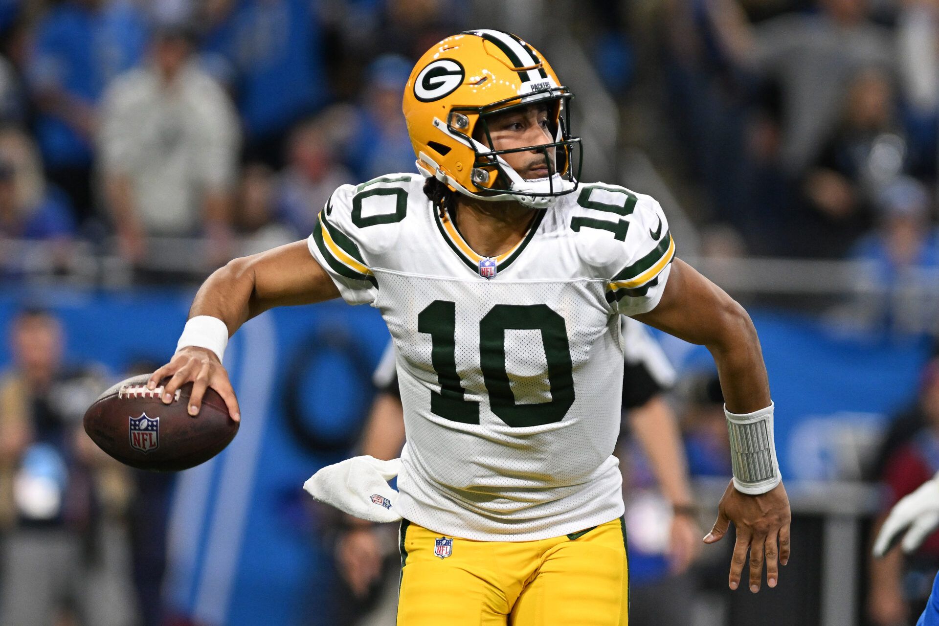 Dec 5, 2024; Detroit, Michigan, USA; Green Bay Packers quarterback Jordan Love (10) looks for an open receiver as he scrambles out of the pocket against the Detroit Lions in the third quarter at Ford Field. Mandatory Credit: Lon Horwedel-Imagn Images