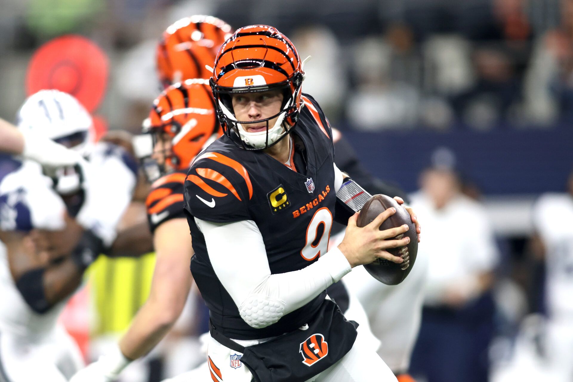 Dec 9, 2024; Arlington, Texas, USA; Cincinnati Bengals quarterback Joe Burrow (9) rolls out to pass against the Dallas Cowboys in the first quarter at AT&T Stadium. Mandatory Credit: Tim Heitman-Imagn Images