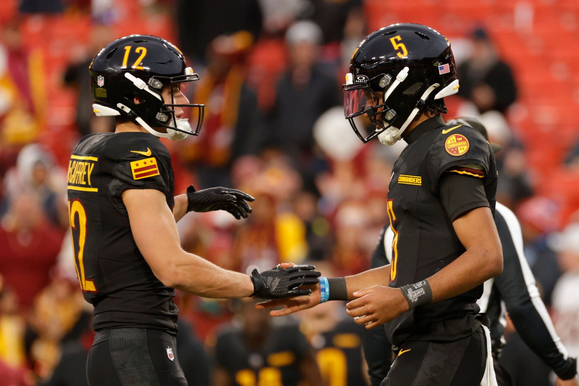 Dec 1, 2024; Landover, Maryland, USA; Washington Commanders quarterback Jayden Daniels (5) celebrates with Commanders wide receiver Luke McCaffrey (12) after defeating the Tennessee Titans at Northwest Stadium. Mandatory Credit: Amber Searls-Imagn Images