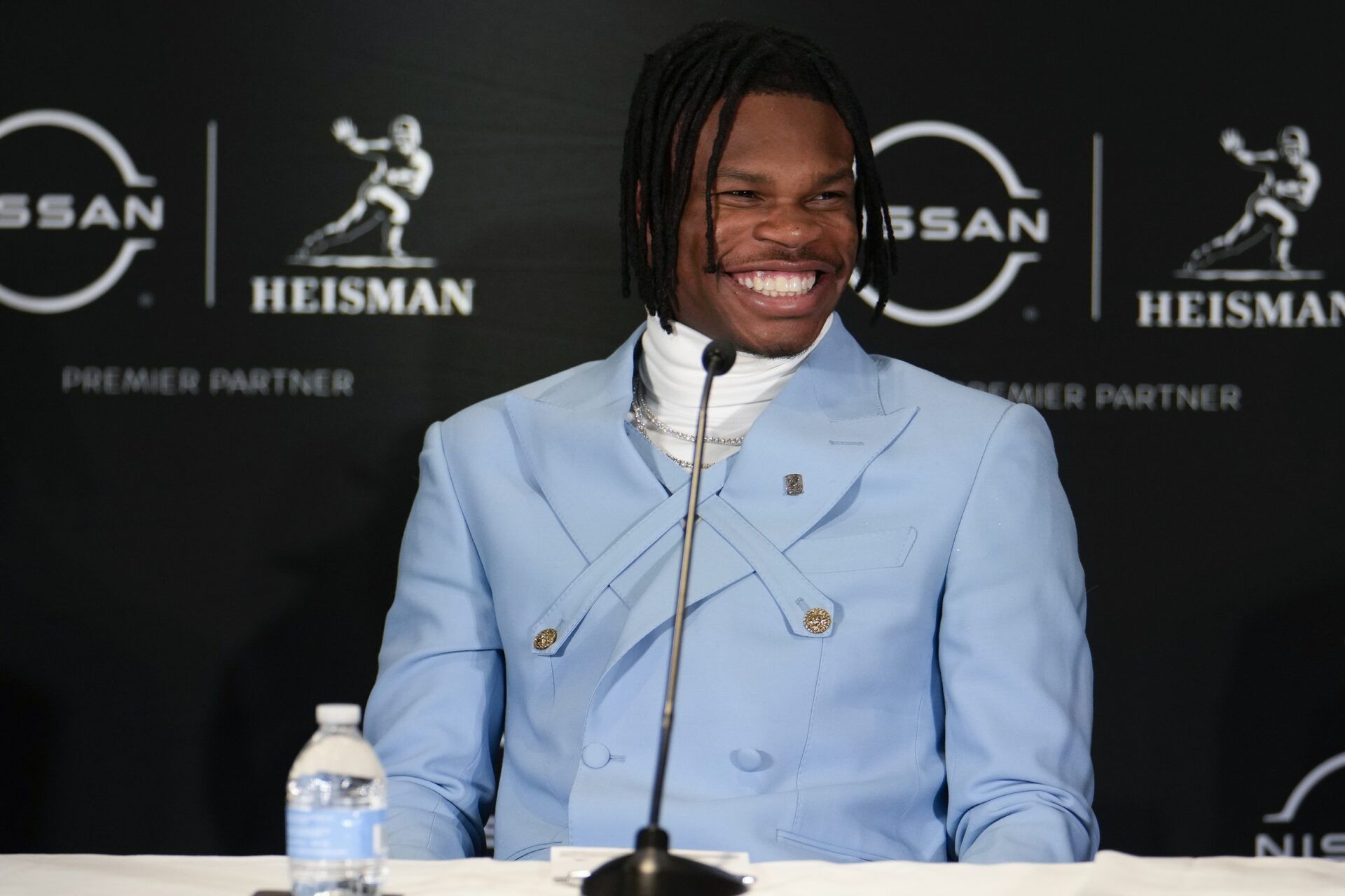 Colorado Buffaloes wide receiver/cornerback Travis Hunter smiles on stage during a press conference before the 2024 Heisman Trophy Presentation.