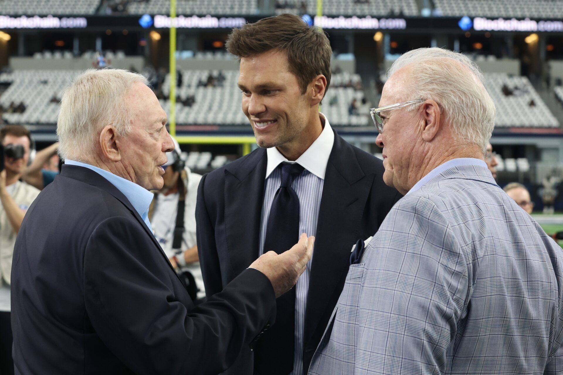 Dallas Cowboys owner Jerry Jones, Fox Sports commentator Tom Brady and Cowboys CEO Stephen Jones talk on the field before a game between the New Orleans Saints and Cowboys at AT&T Stadium.