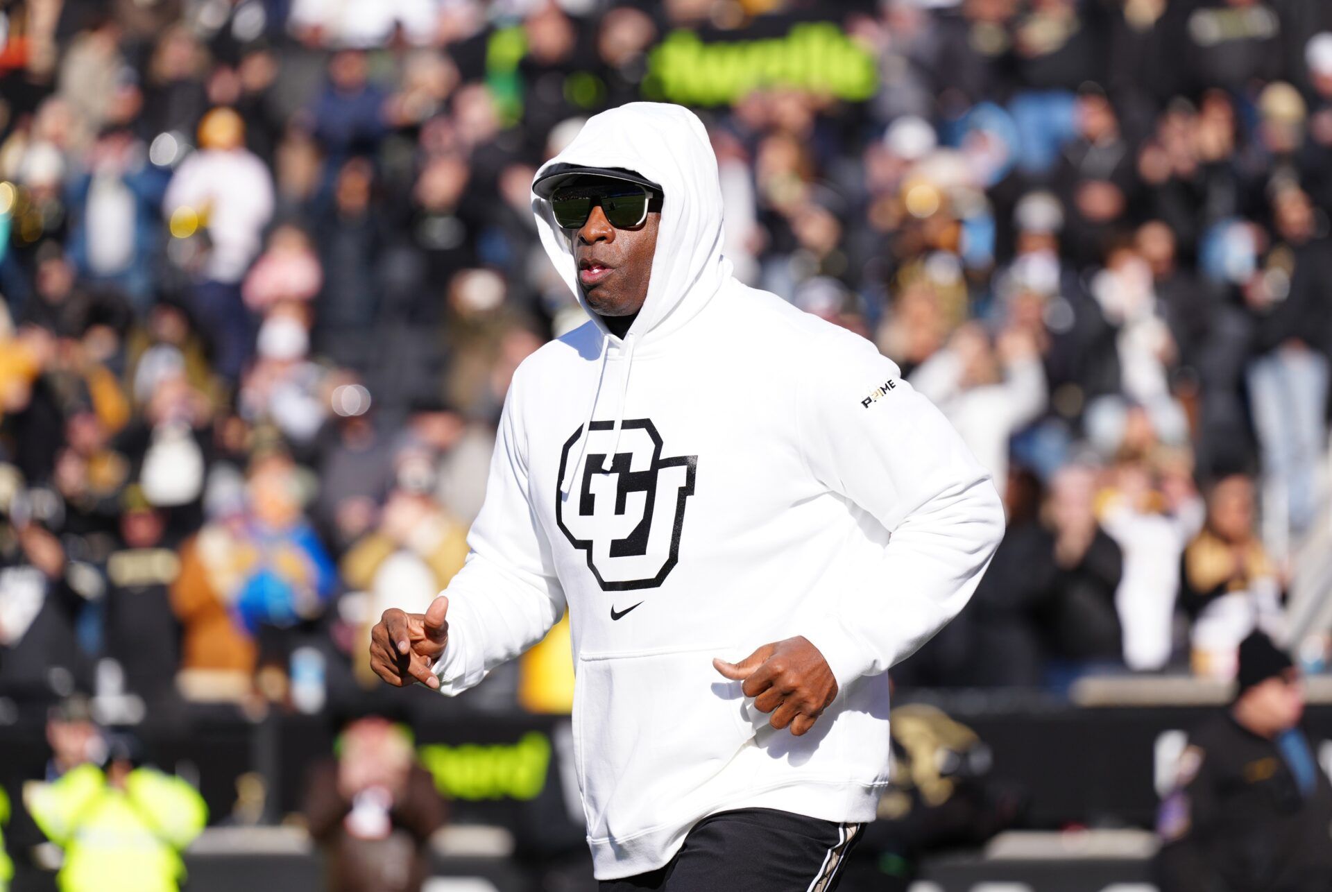 Colorado Buffaloes head coach Deion Sanders runs onto the field before the game against the Oklahoma State Cowboys at Folsom Field.