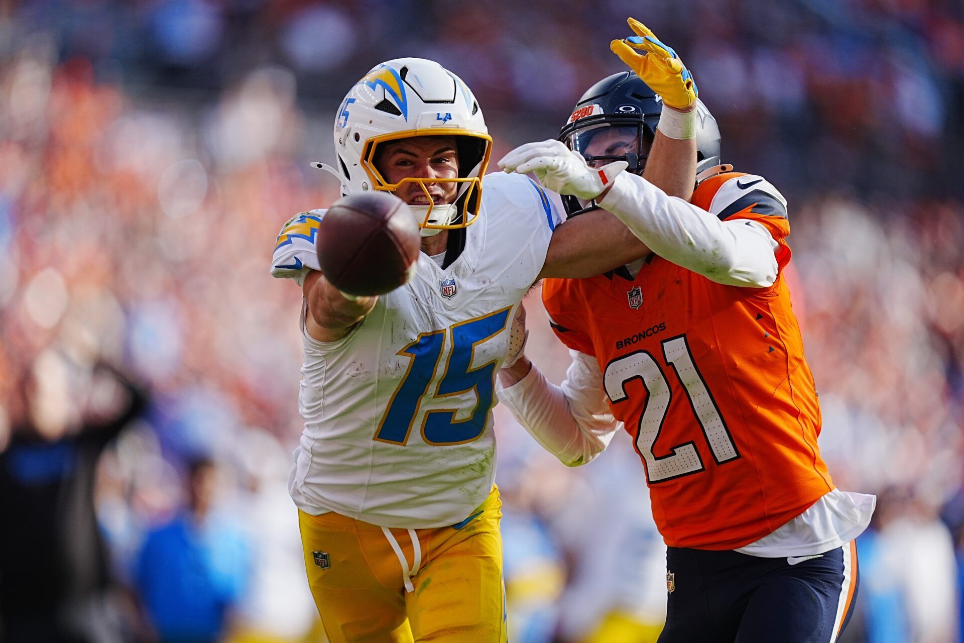 Denver Broncos cornerback Riley Moss (21) breaks up a pass to Los Angeles Chargers wide receiver Ladd McConkey (15) in the second half at Empower Field at Mile High.