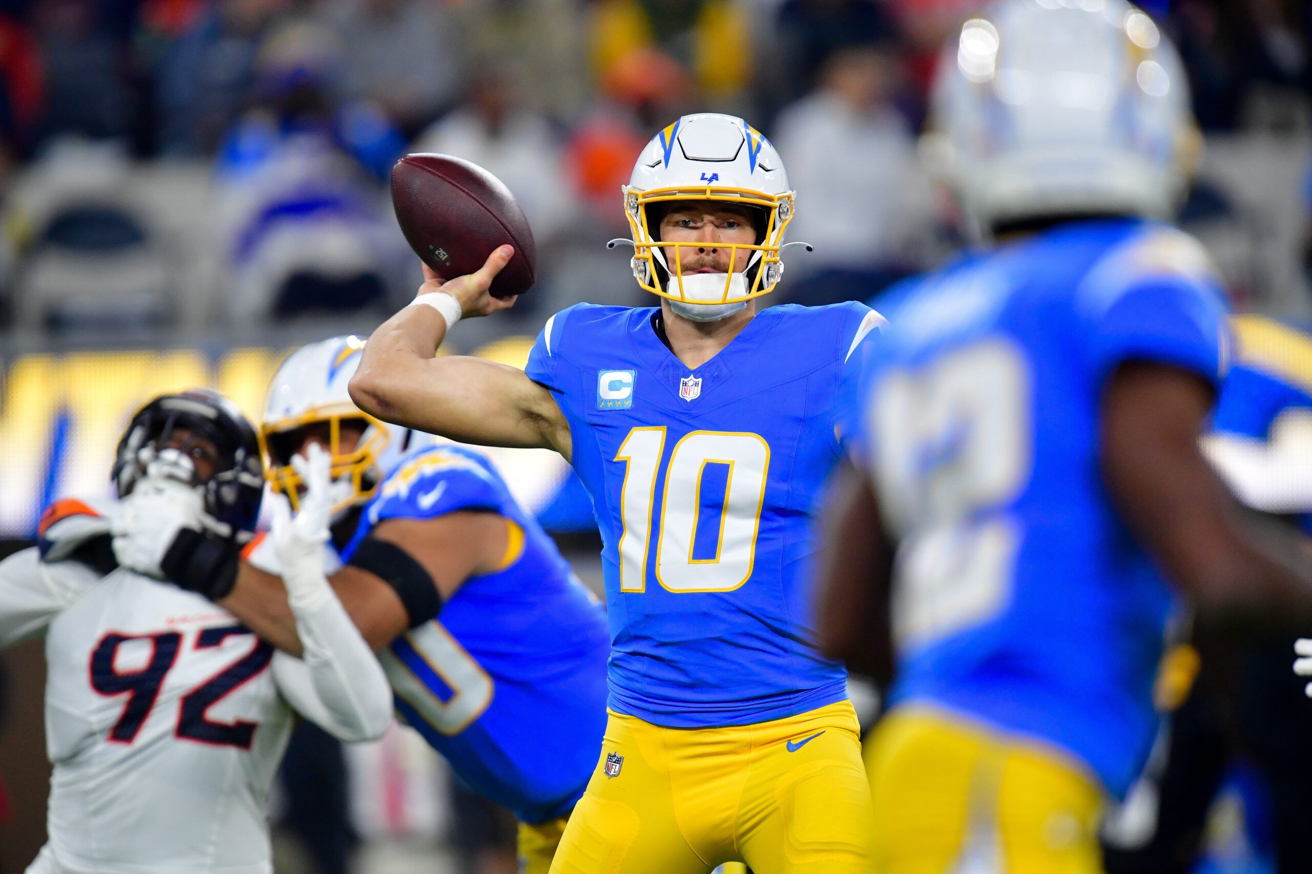 Dec 19, 2024; Inglewood, California, USA; Los Angeles Chargers quarterback Justin Herbert (10) throws against the Denver Broncos during the first half at SoFi Stadium. Mandatory Credit: Gary A. Vasquez-Imagn Images