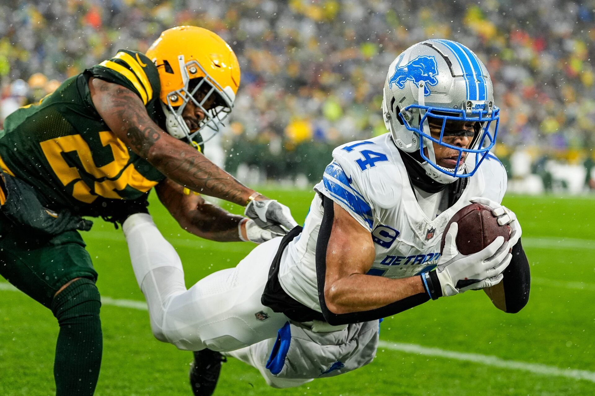 Detroit Lions wide receiver Amon-Ra St. Brown (14) makes a catch for a touchdown against Green Bay Packers cornerback Keisean Nixon (25) during the first half at Lambeau Field in Green Bay, Wis. on Sunday, Nov. 3, 2024.