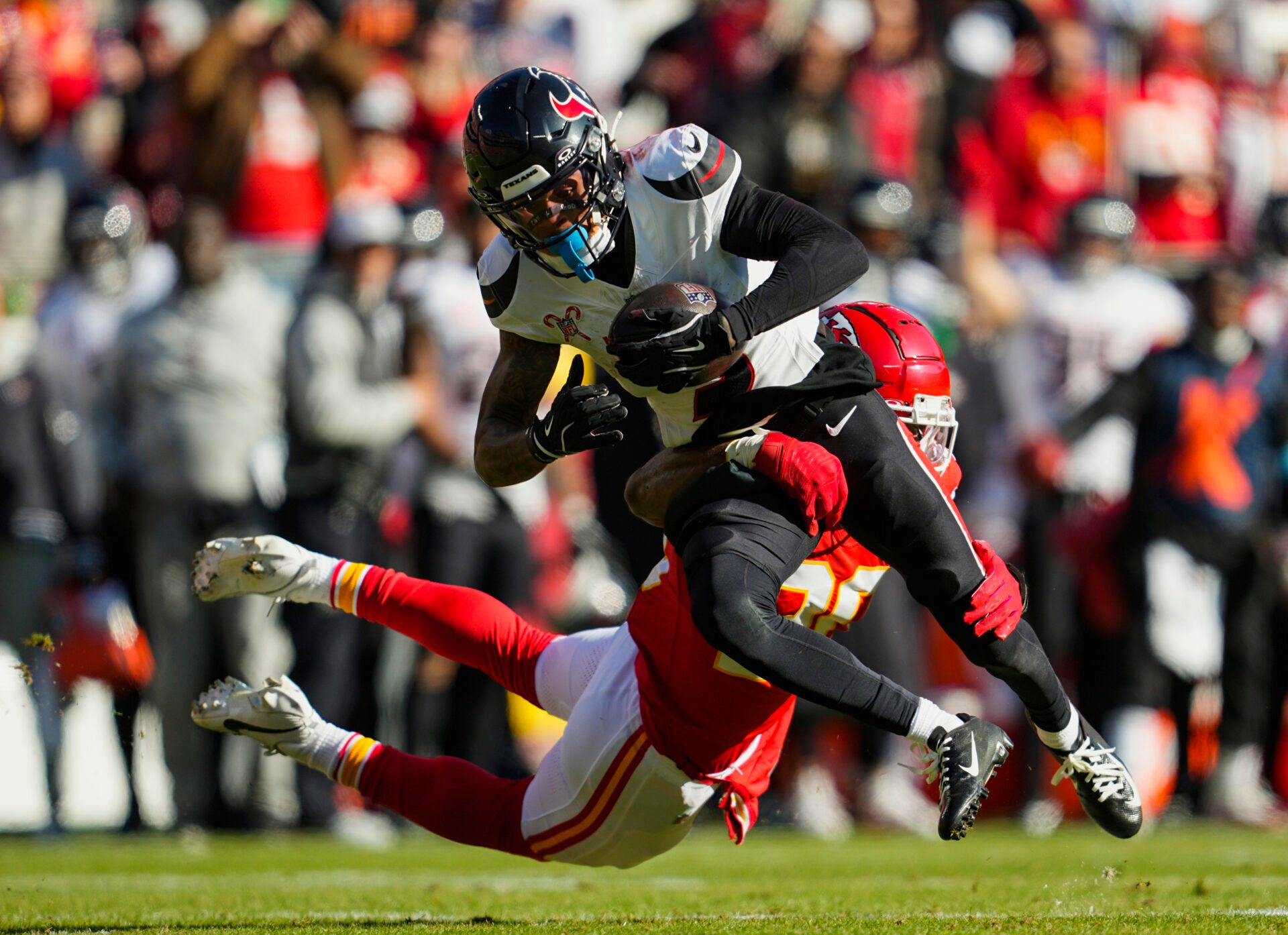 Houston Texans wide receiver Tank Dell (3) is tackled by Kansas City Chiefs safety Justin Reid (20) during the first half at GEHA Field at Arrowhead Stadium.