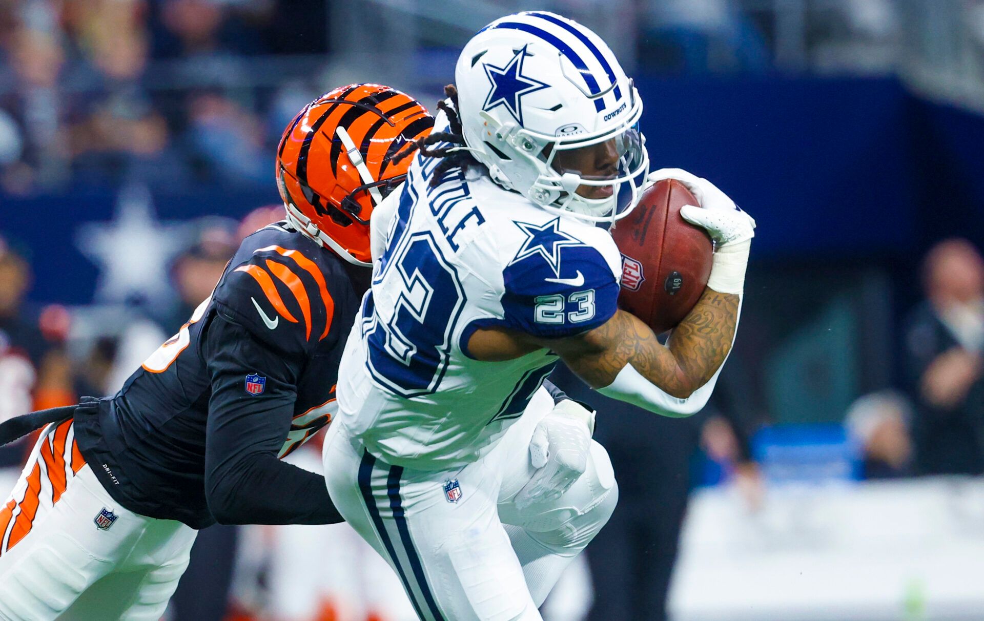 Dec 9, 2024; Arlington, Texas, USA; Dallas Cowboys running back Rico Dowdle (23) runs with the ball as Cincinnati Bengals cornerback DJ Ivey (38) defends during the first quarter at AT&T Stadium. Mandatory Credit: Kevin Jairaj-Imagn Images