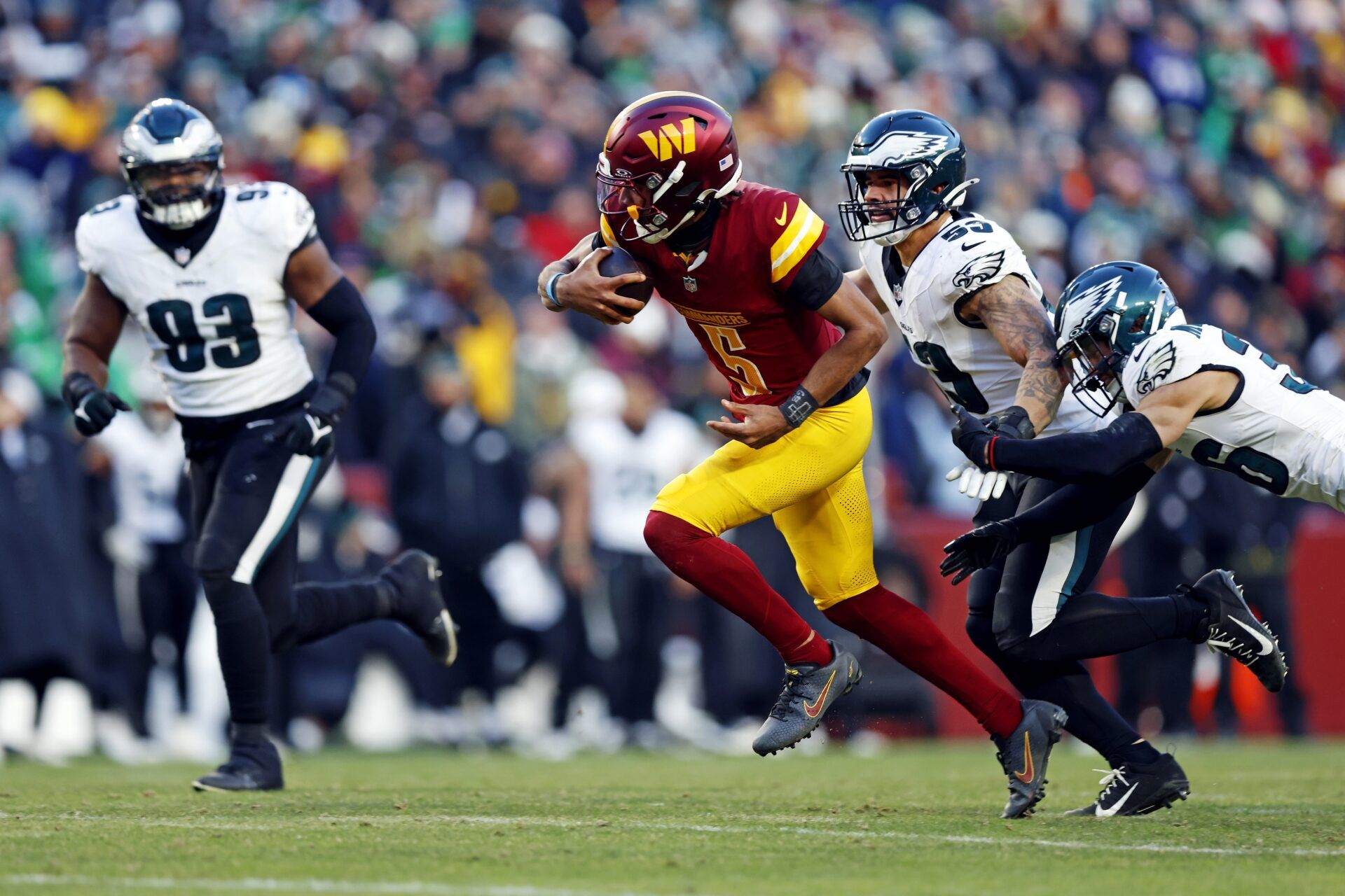 Washington Commanders quarterback Jayden Daniels (5) runs the ball against Philadelphia Eagles linebacker Zack Baun (53) during the fourth quarter at Northwest Stadium.