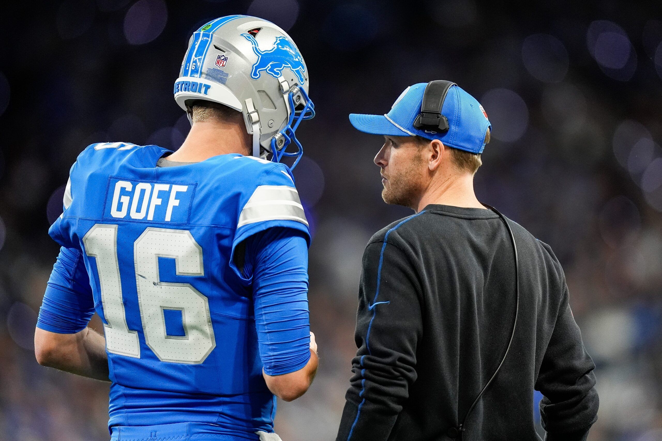 Detroit Lions quarterback Jared Goff (16), left, talks to offensive coordinator Ben Johnson before a play against Chicago Bears during the first half at Ford Field in Detroit on Thursday, Nov. 28, 2024.