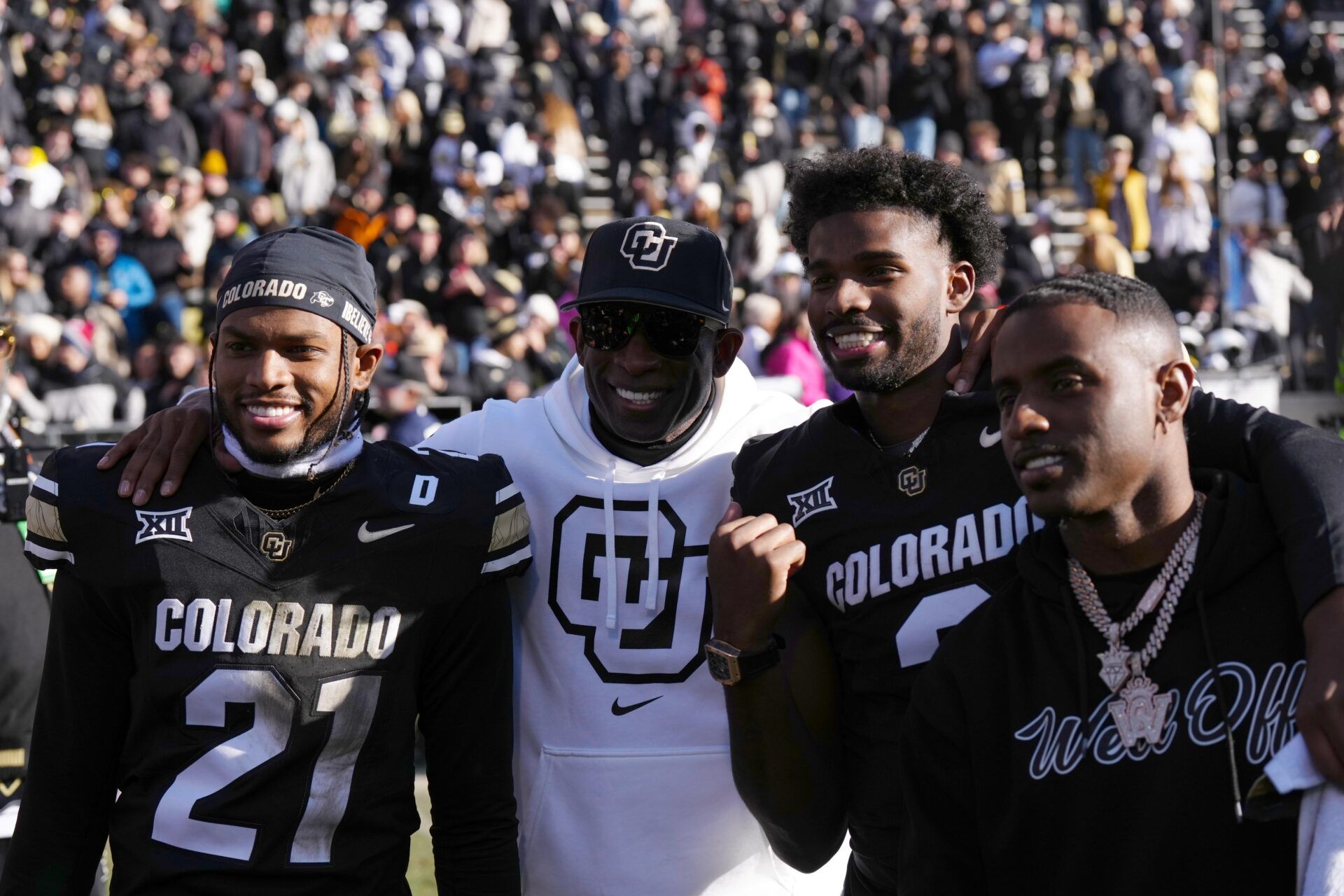 Colorado Buffaloes safety Shilo Sanders (21) and head coach Deion Sanders and quarterback Shedeur Sanders (2) and social media producer Deion Sanders Jr. following the win against the Oklahoma State Cowboys at Folsom Field.