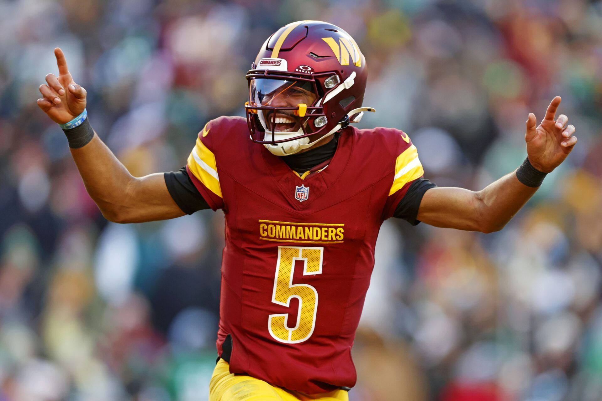 Washington Commanders quarterback Jayden Daniels (5) celebrates after throwing a touchdown during the fourth quarter against the Philadelphia Eagles at Northwest Stadium.