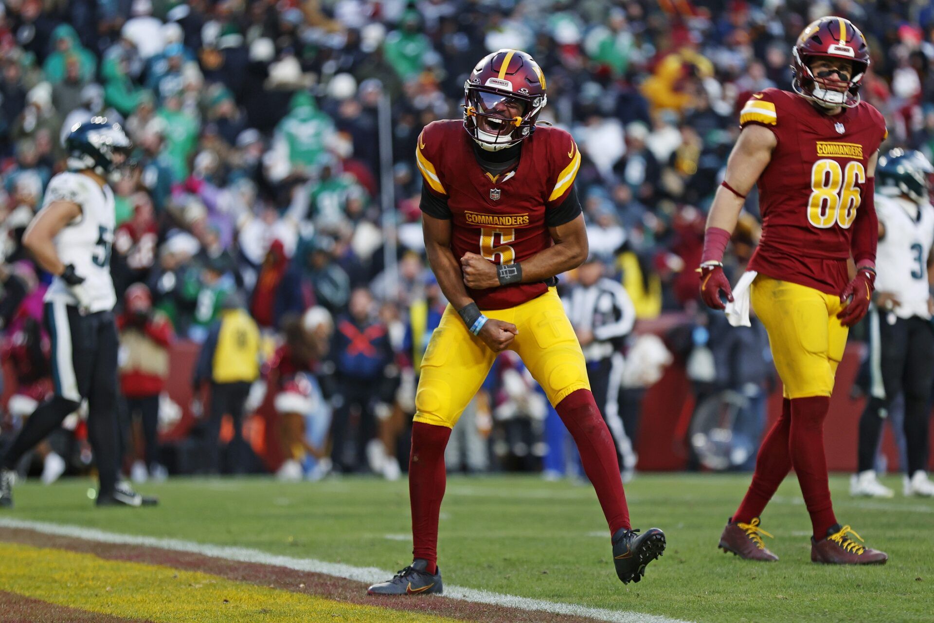 Washington Commanders quarterback Jayden Daniels (5) celebrates after throwing the game winning touchdown during the fourth quarter against the Philadelphia Eagles at Northwest Stadium.