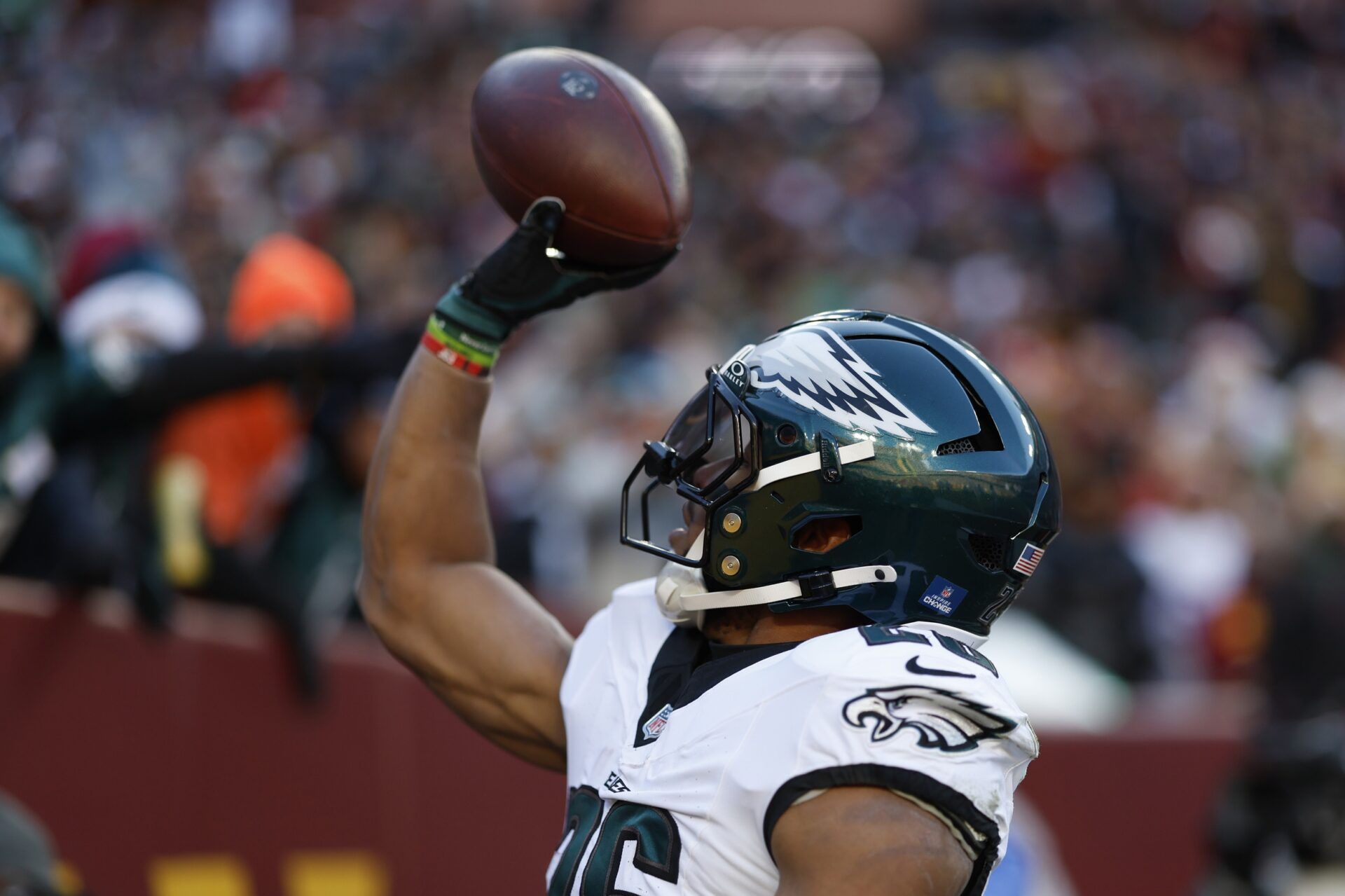 Philadelphia Eagles running back Saquon Barkley (26) tosses the ball into the stands after scoring a touchdown against the Washington Commanders during the first quarter at Northwest Stadium.