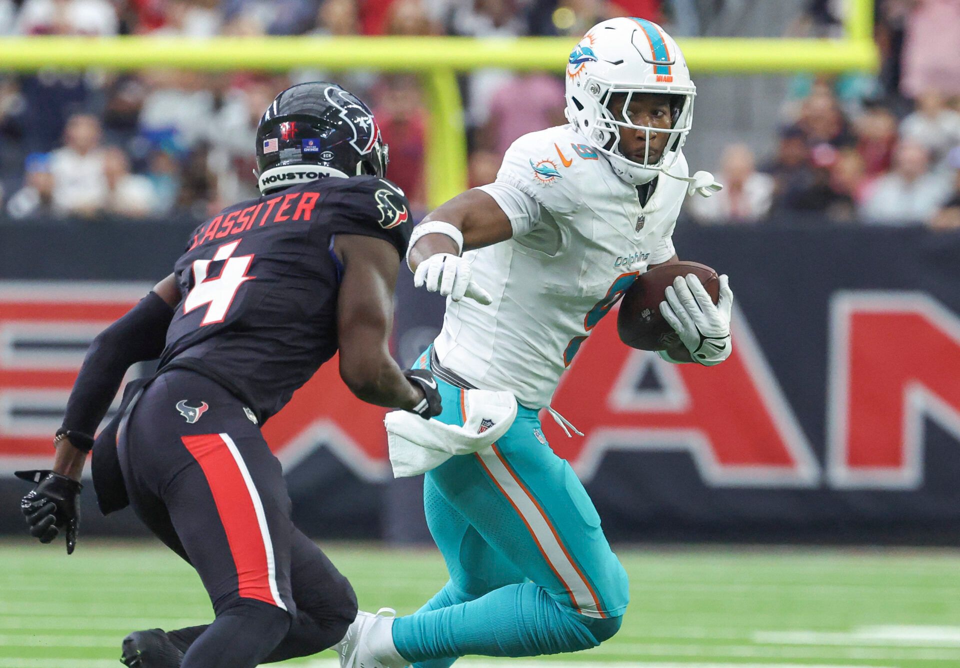 Dec 15, 2024; Houston, Texas, USA; Miami Dolphins tight end Jonnu Smith (9) runs with the ball after a reception as Houston Texans safety Calen Bullock (21) attempts to make a tackle during the fourth quarter at NRG Stadium. Mandatory Credit: Troy Taormina-Imagn Images