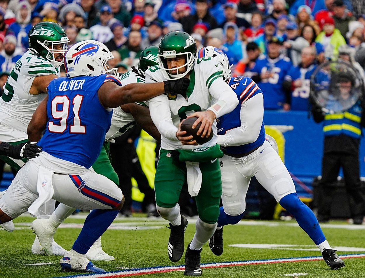 New York Jets quarterback Aaron Rodgers (8) gets sacked by Buffalo Bills defensive tackle Ed Oliver (91) and Buffalo Bills linebacker Von Miller (40) during second half action at the Bills home game against the New York Jets at Highmark Stadium in Orchard Park on Dec. 29, 2024.