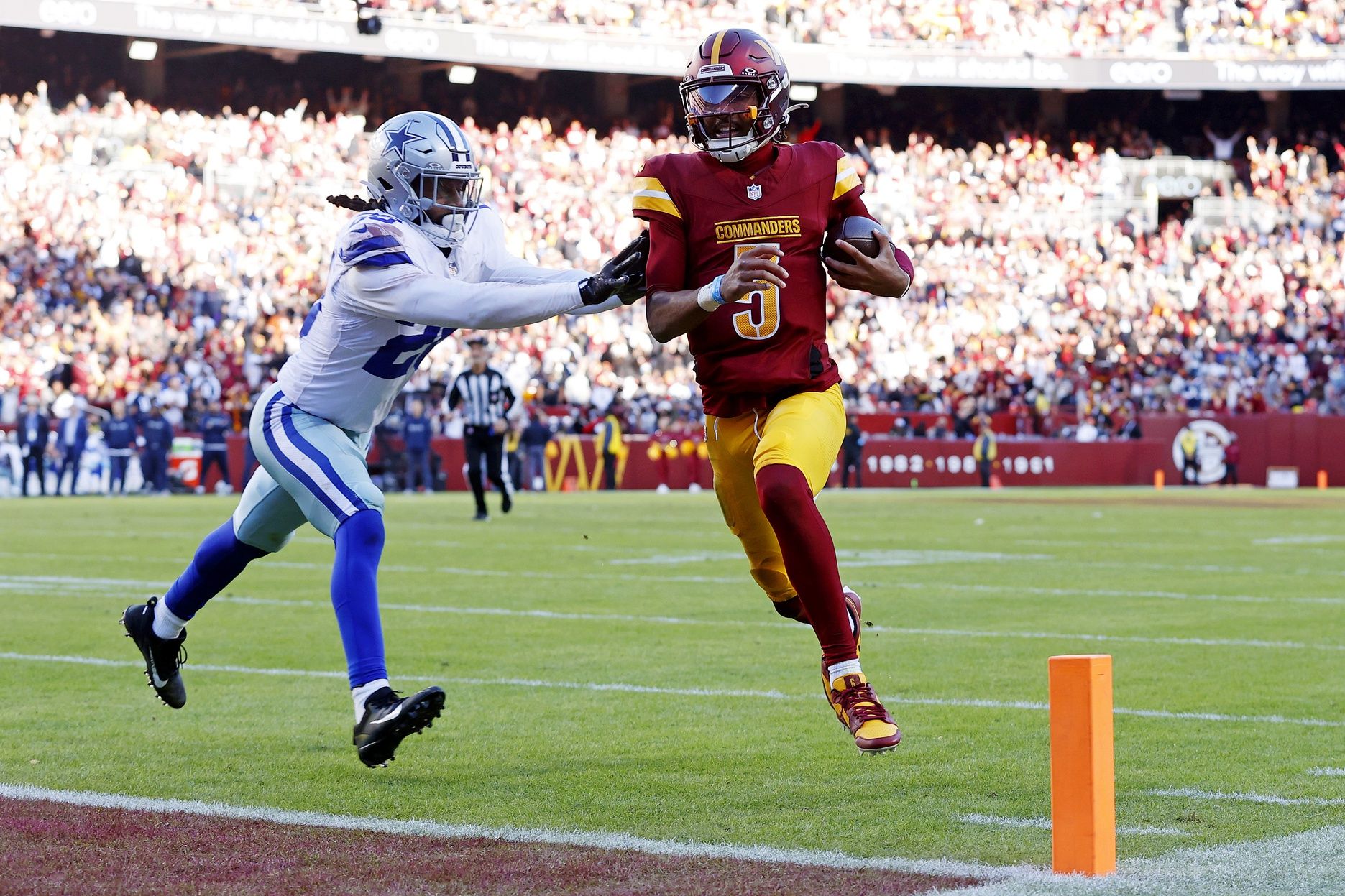 Washington Commanders quarterback Jayden Daniels (5) runs for a touchdown against Dallas Cowboys safety Malik Hooker (28) during the third quarter at Northwest Stadium.