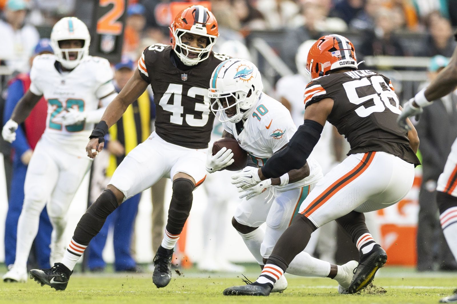 Miami Dolphins wide receiver Tyreek Hill (10) runs the ball as Cleveland Browns linebacker Jordan Hicks (58) and linebacker Mohamoud Diabate (43) move to tackle him during the first quarter at Huntington Bank Field.