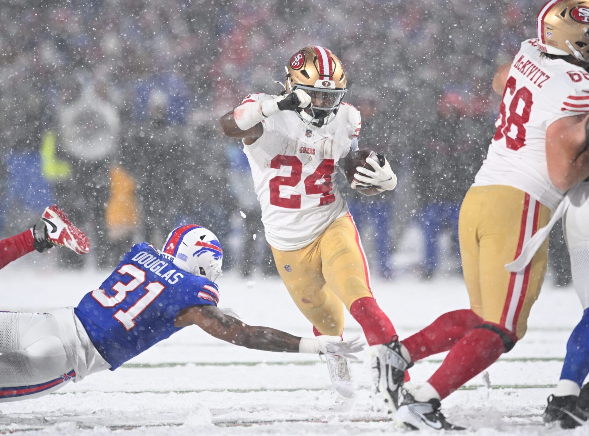 San Francisco 49ers running back Jordan Mason (24) avoids a tackle by Buffalo Bills cornerback Rasul Douglas (31) in the third quarter at Highmark Stadium.