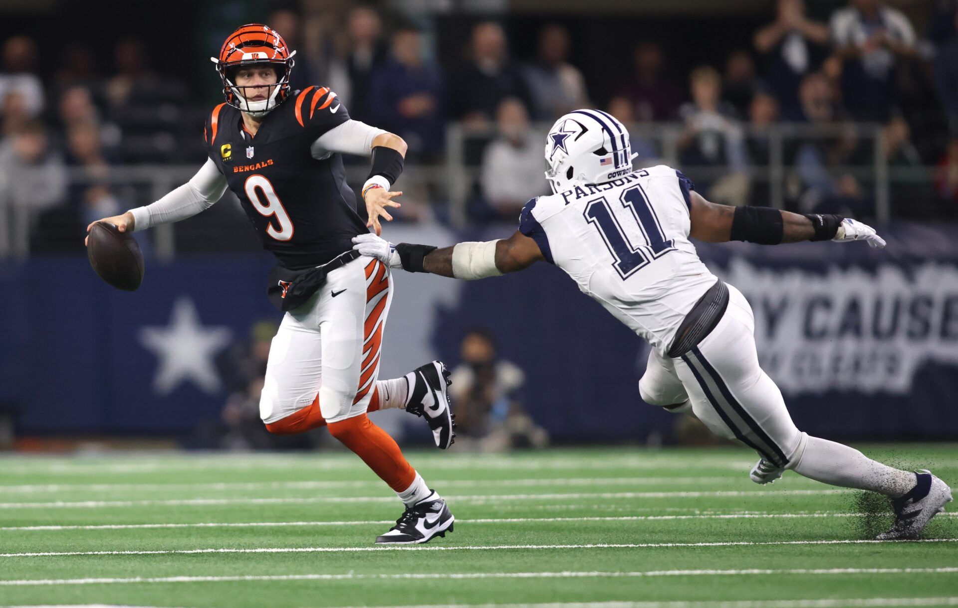 Cincinnati Bengals quarterback Joe Burrow (9) avoids the tackle of Dallas Cowboys linebacker Micah Parsons (11) in the second half at AT&T Stadium.